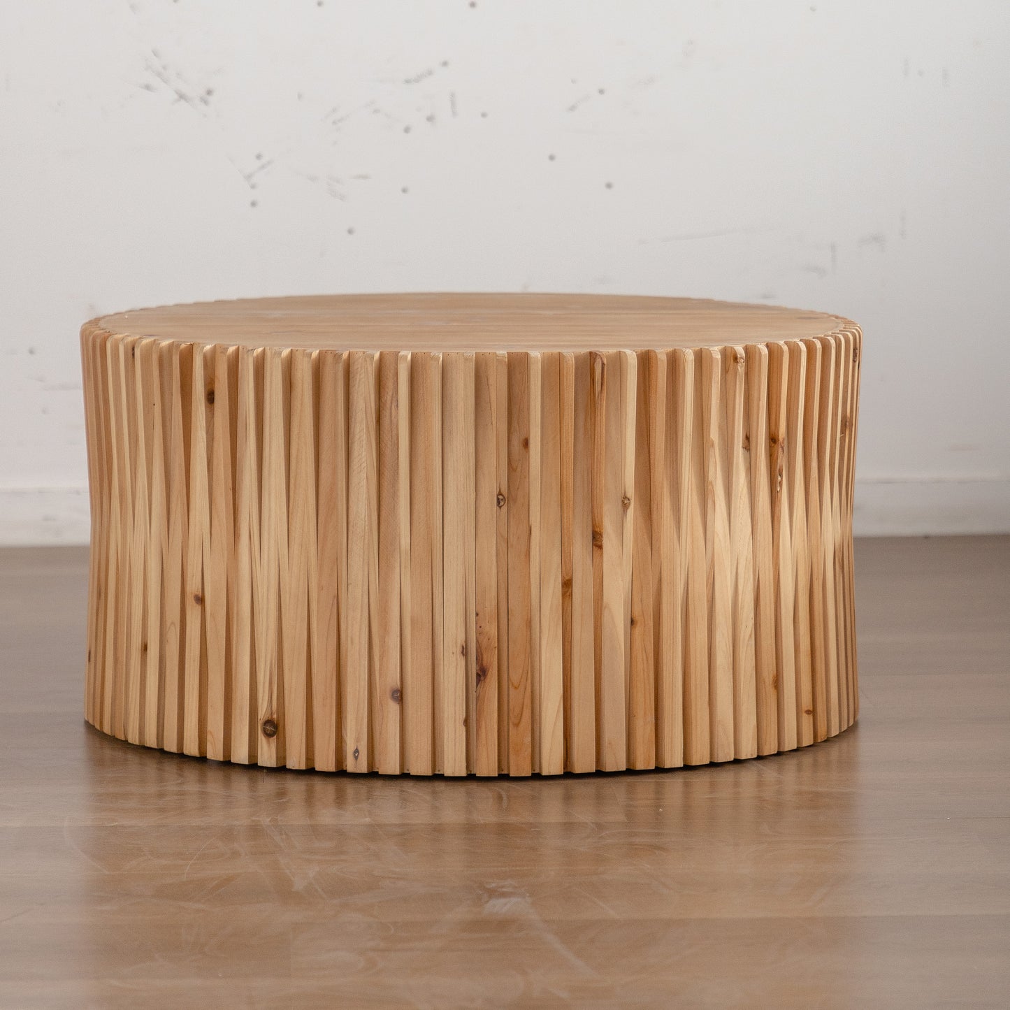 Round natural wood coffee table with fluted detail on base