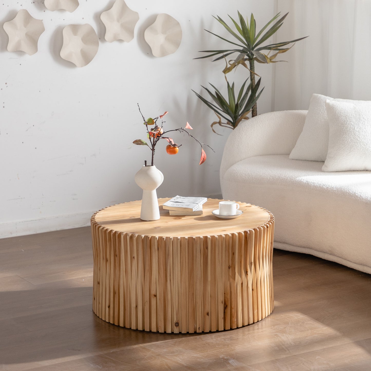 Round wooden coffee table with textured wood slats and a light oak finish