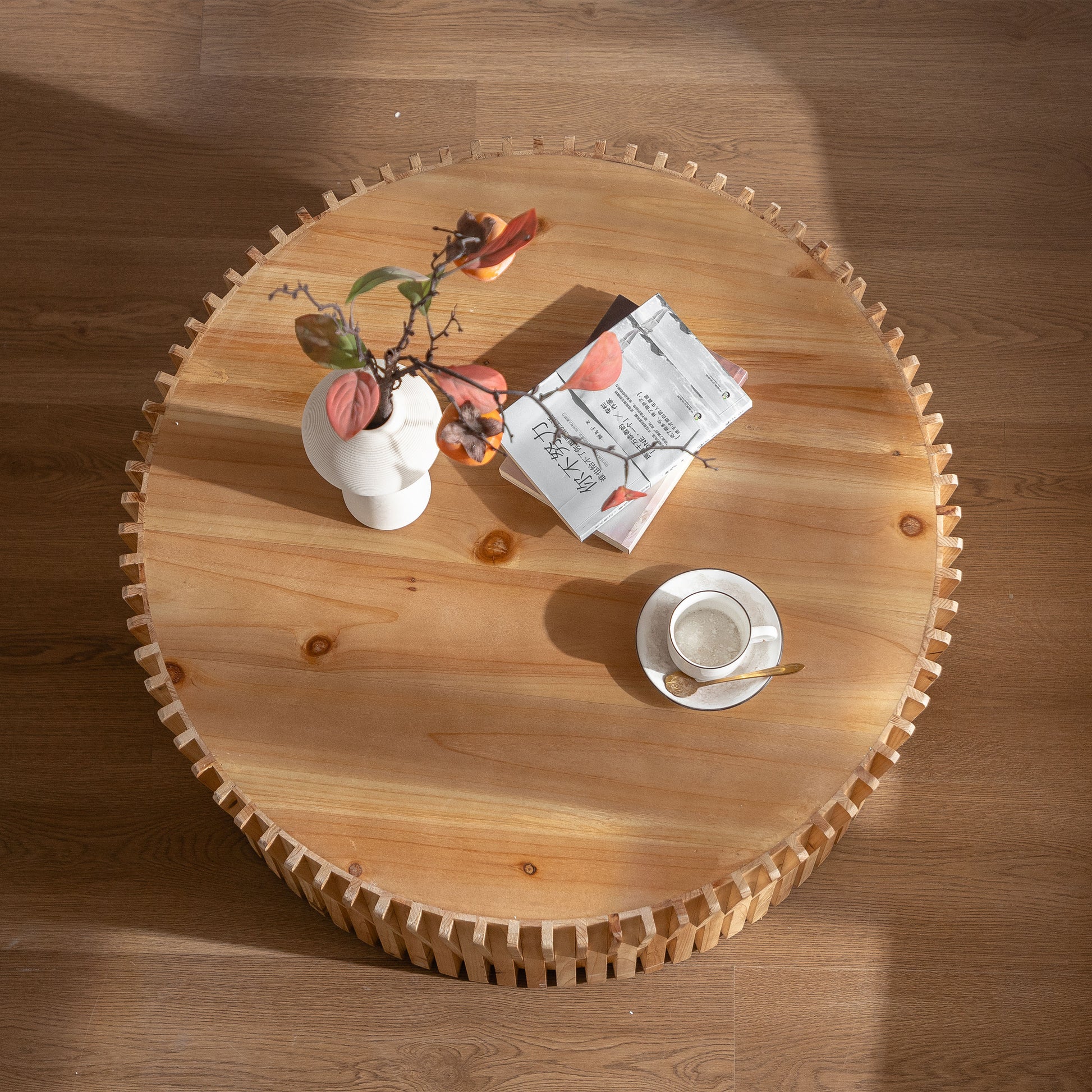 Round wooden coffee table with unique carved edge and decorative items