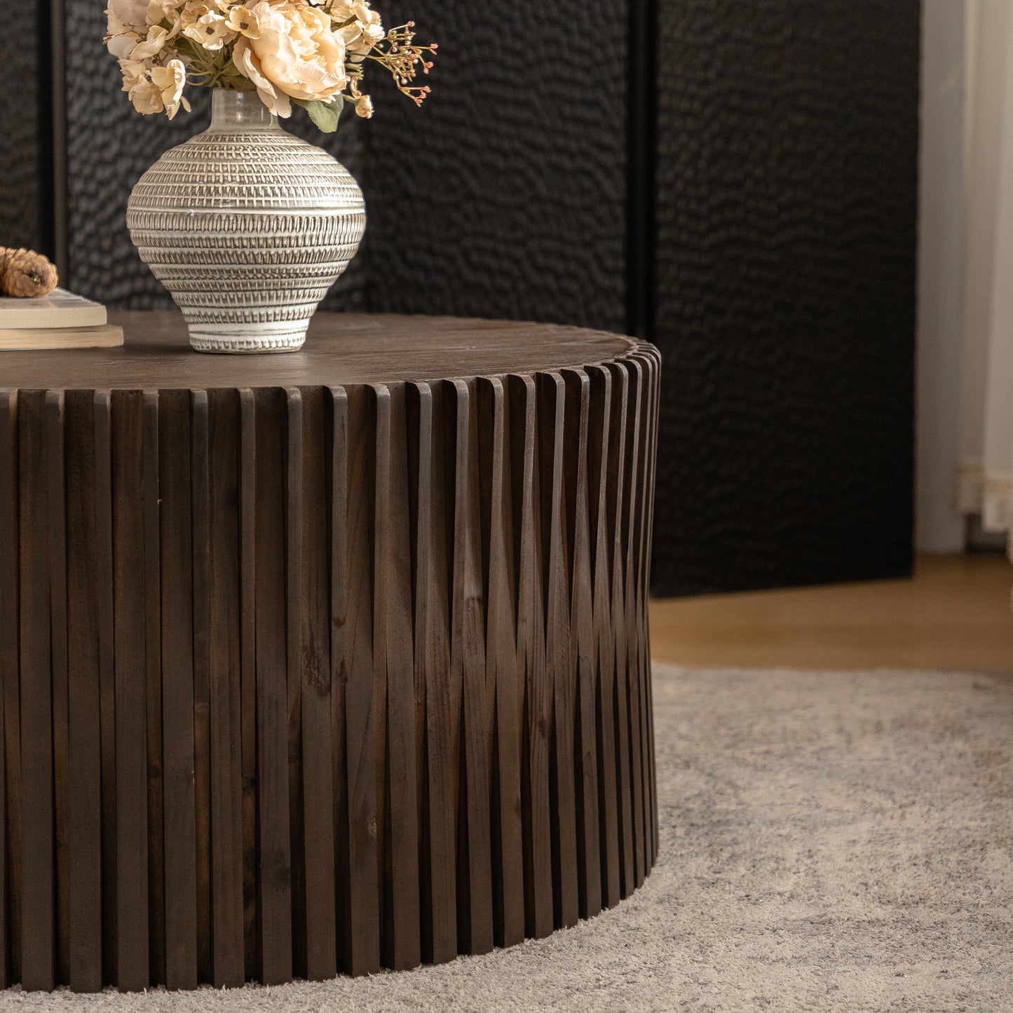 Dark wood coffee table with fluted sides and a round top perfect for modern living rooms