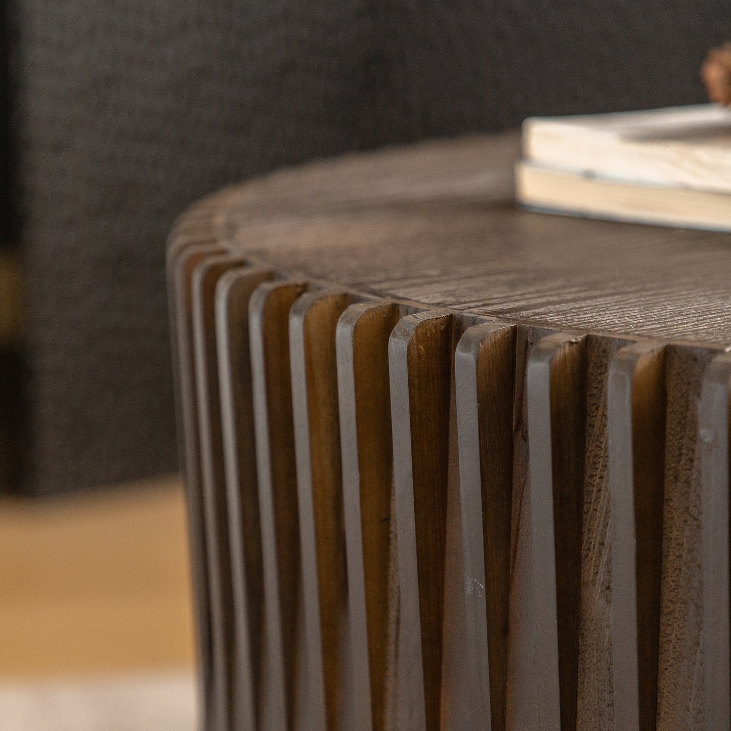 Round wooden coffee table with carved vertical fluting detail