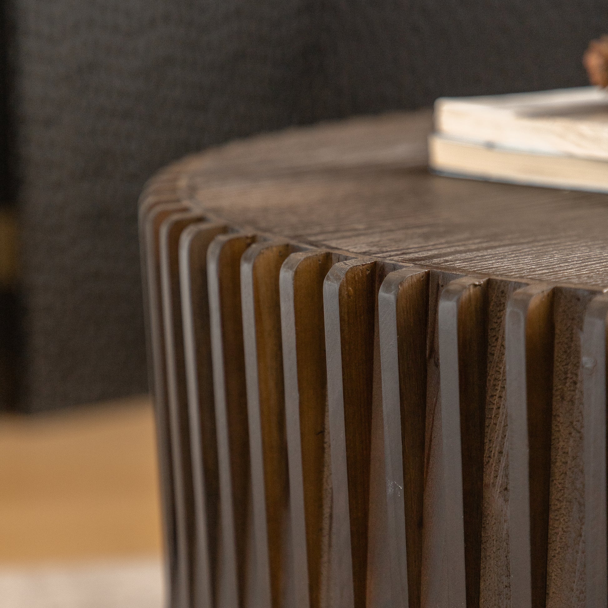 Round wooden coffee table with carved vertical fluting detail