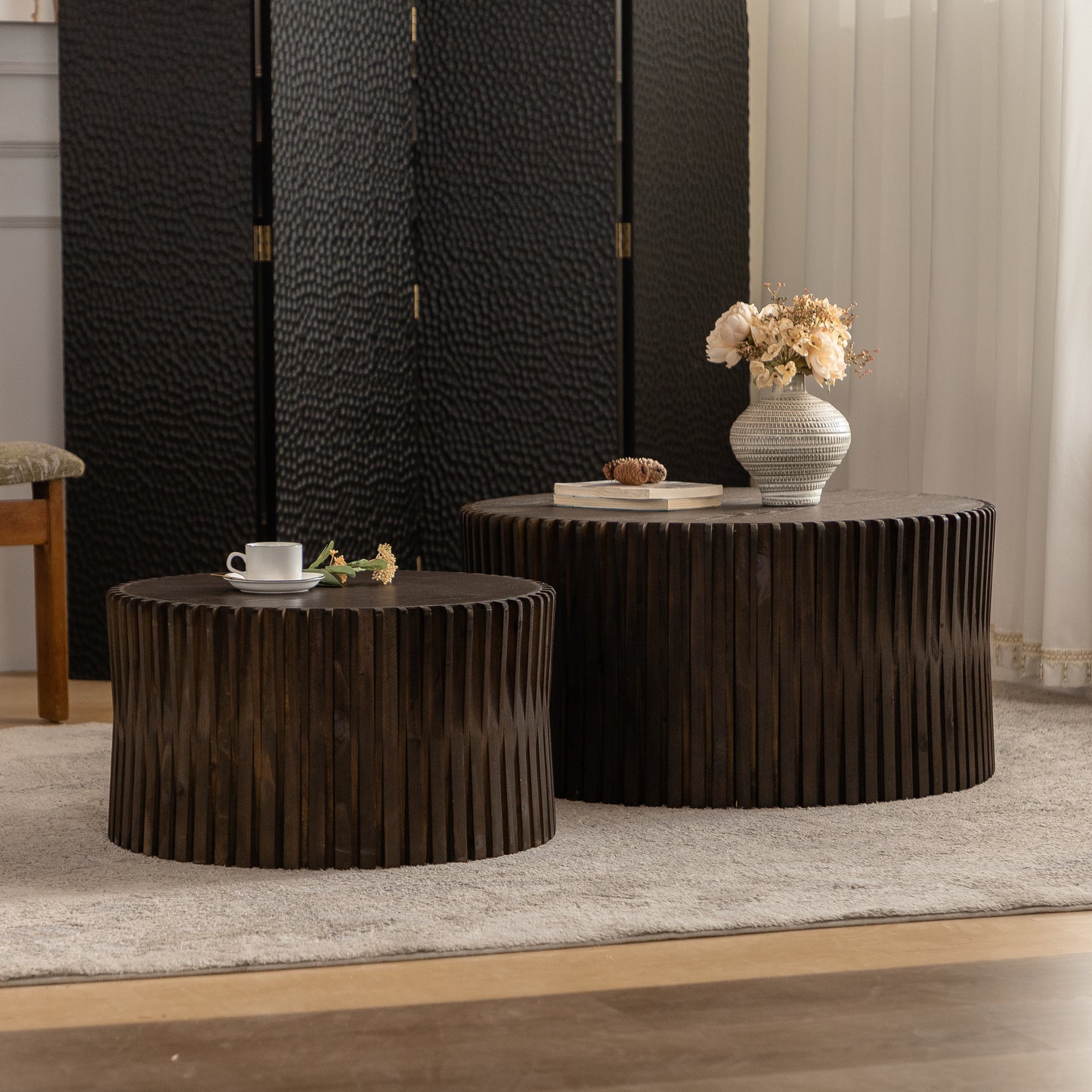 Dark wood round coffee table with vertical slats and a coffee cup