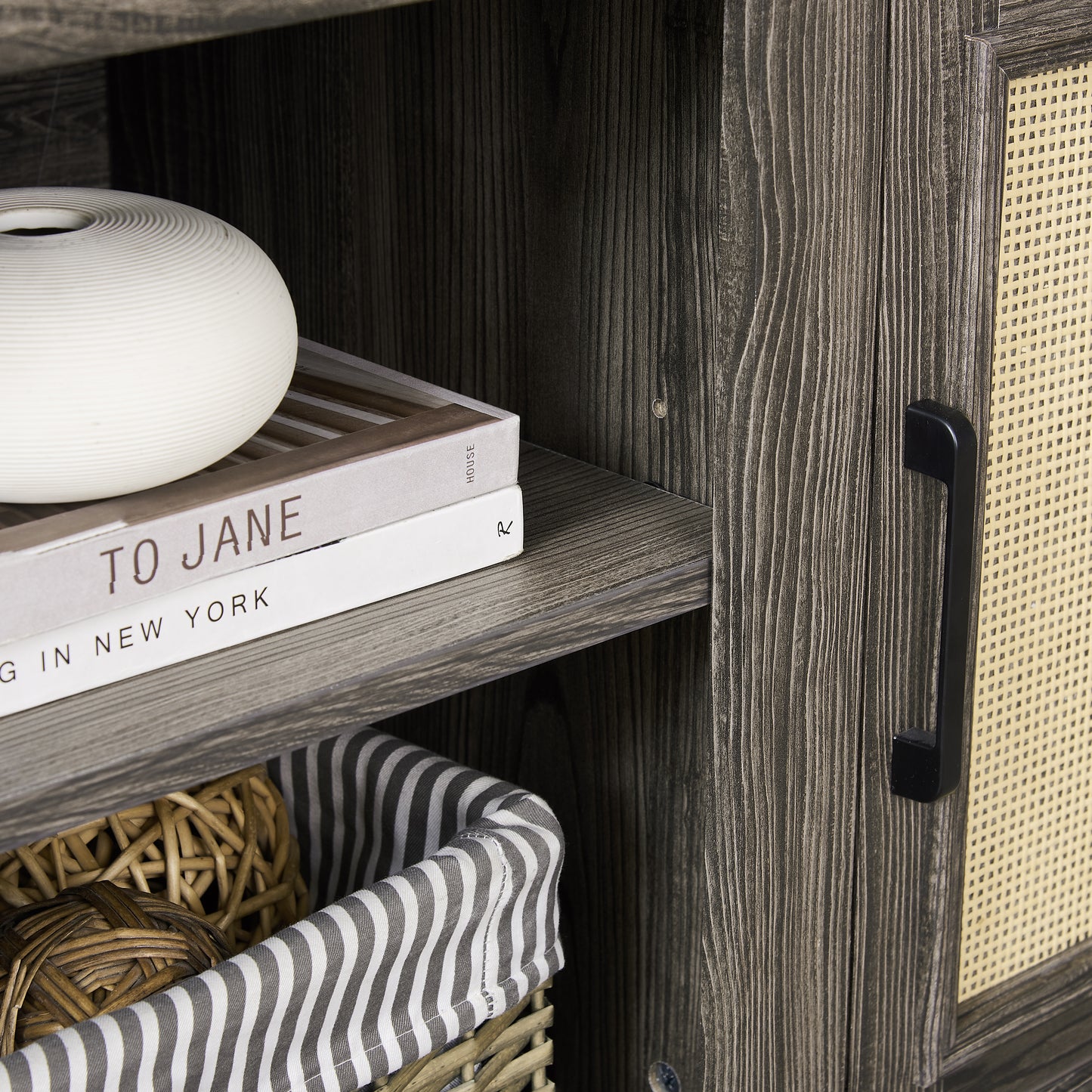 Distressed wood cabinet detail with woven cane door and black handle ideal for storage