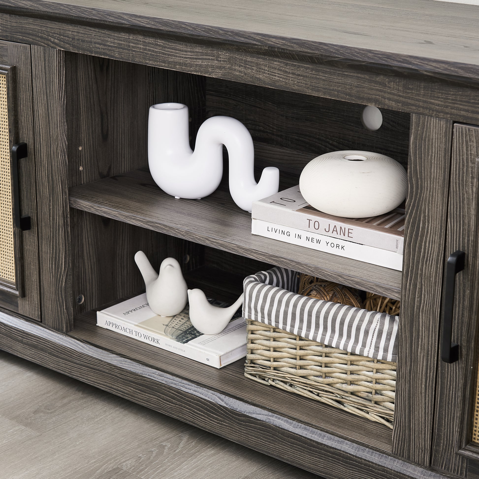 Dark wood TV stand with cane door inserts and decorative ceramic birds on shelf