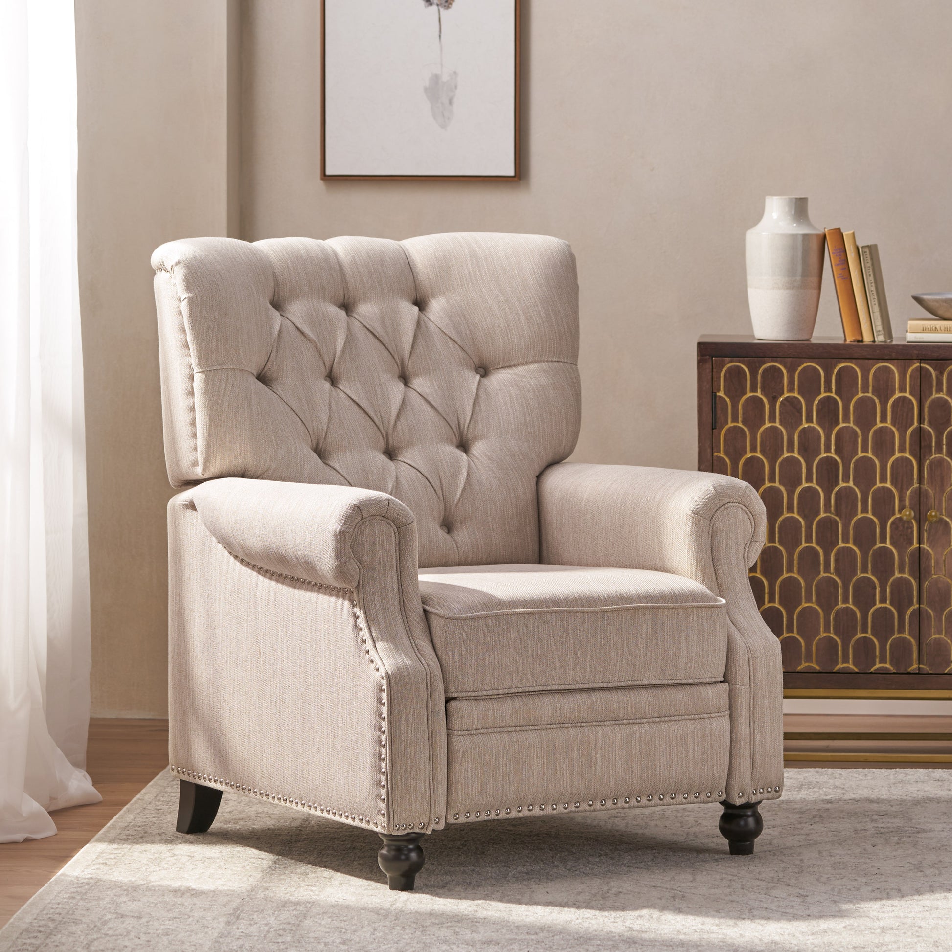 Tufted beige fabric recliner chair with nailhead trim and dark wooden legs ideal for living rooms