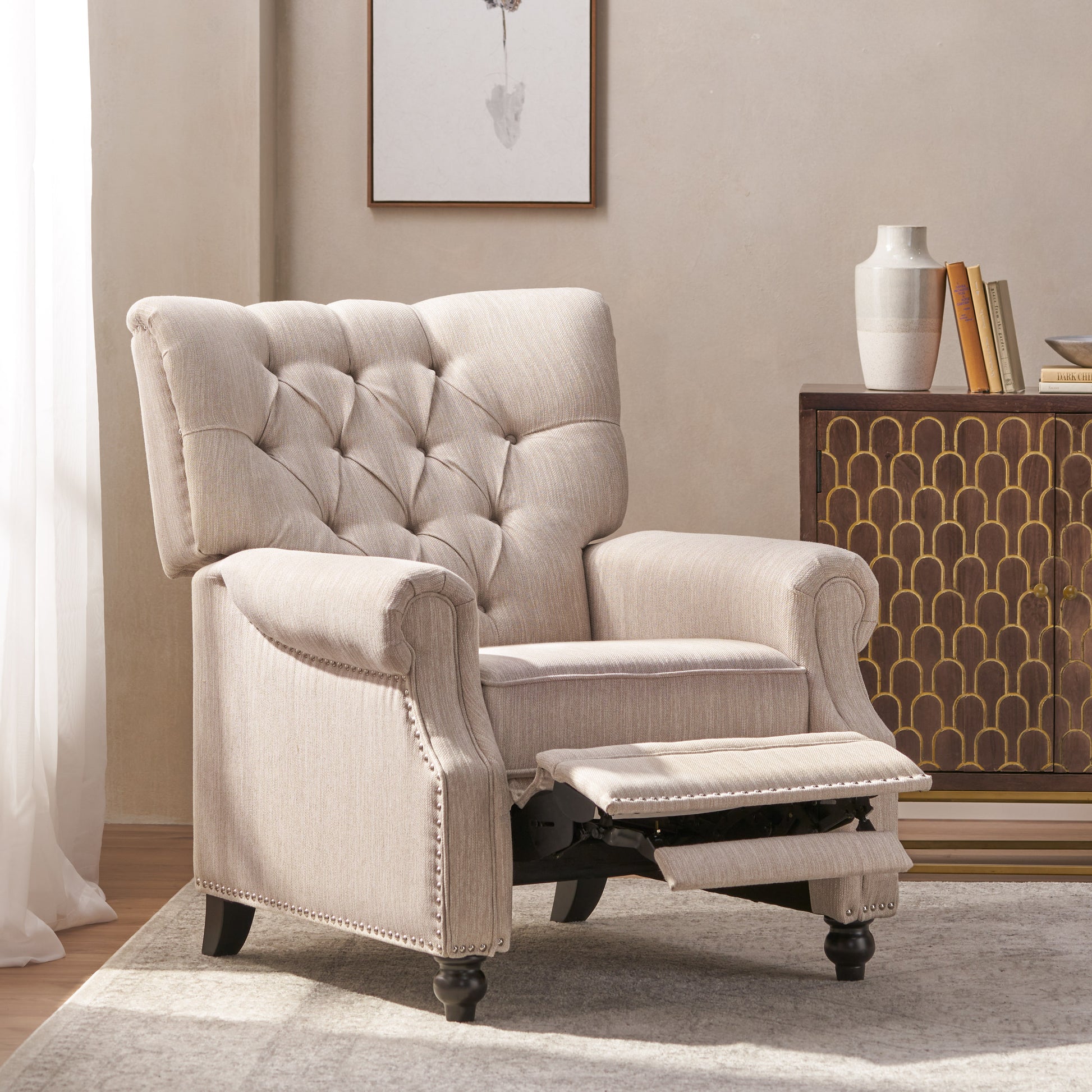 Beige upholstered recliner chair with tufted back and nailhead trim