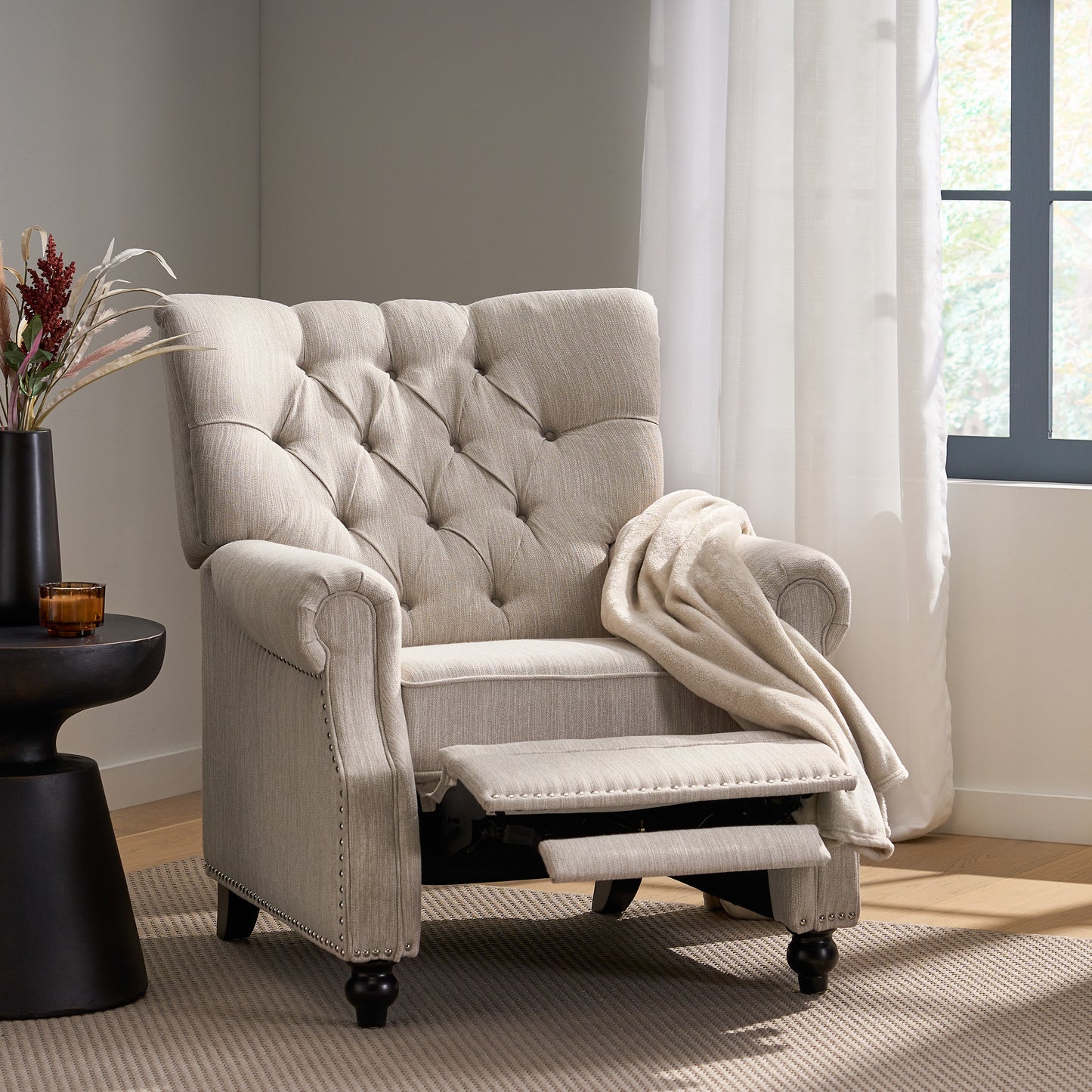 Tufted linen recliner chair in neutral beige with nailhead trim and extended footrest for relaxation