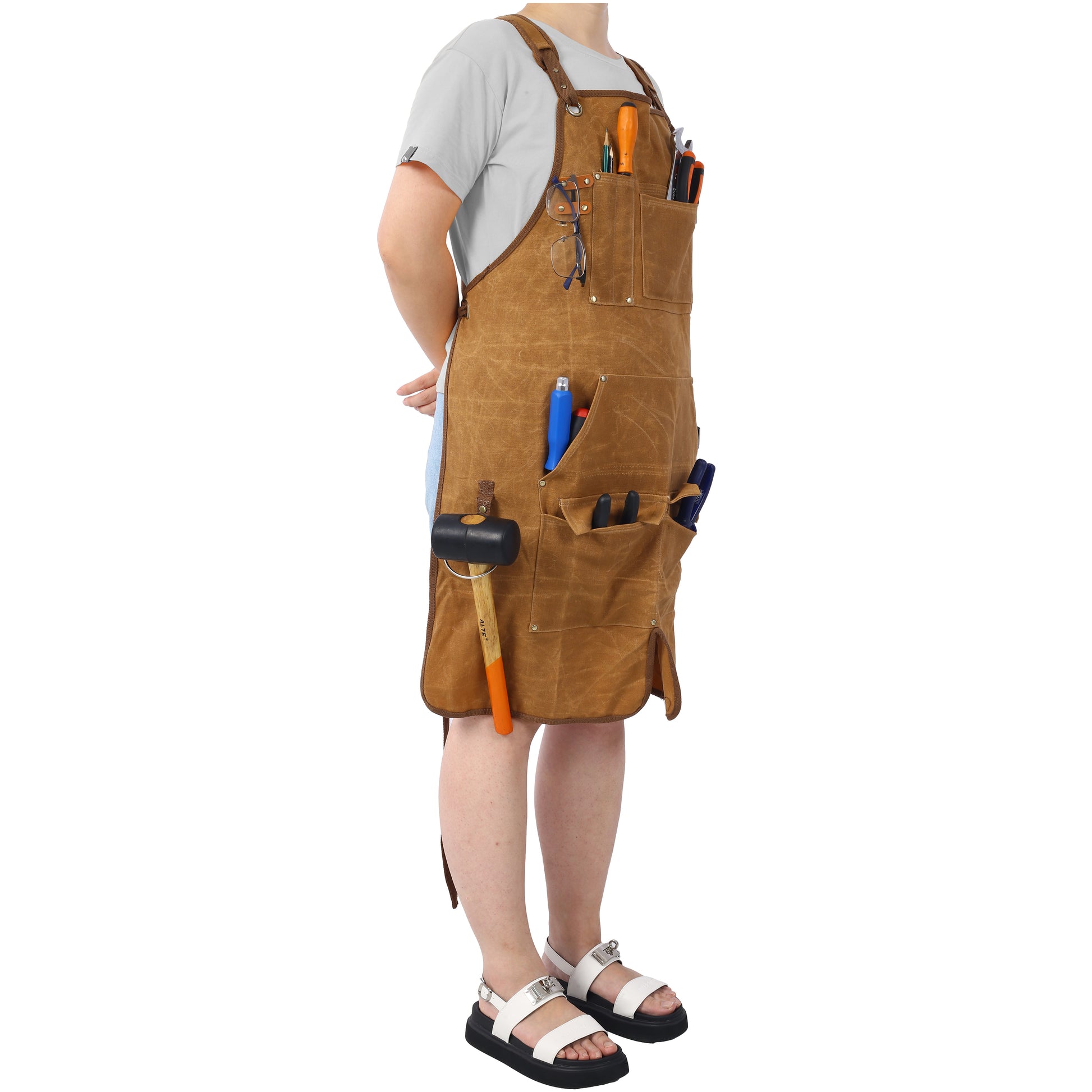 Brown canvas work apron with multiple pockets holding tools and glasses