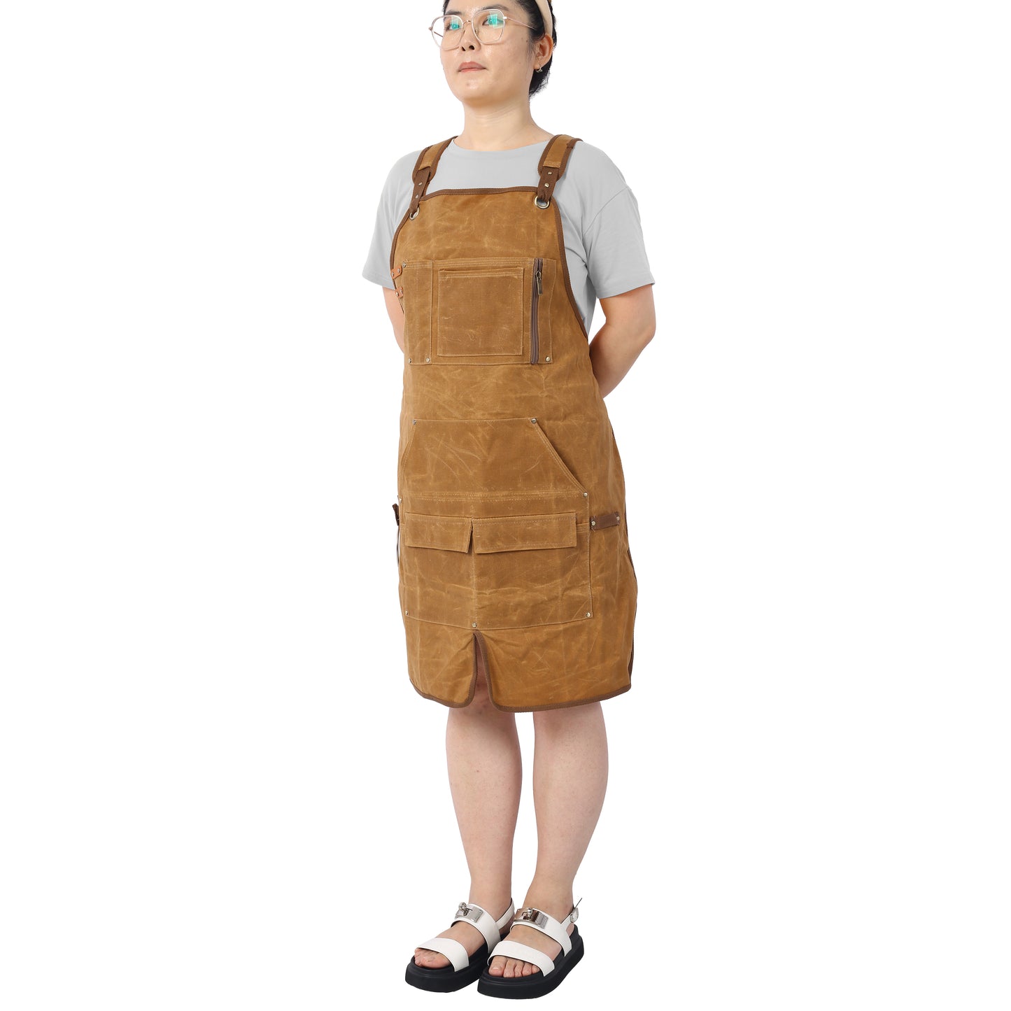 Brown waxed canvas utility apron with multiple pockets and a zippered chest pocket