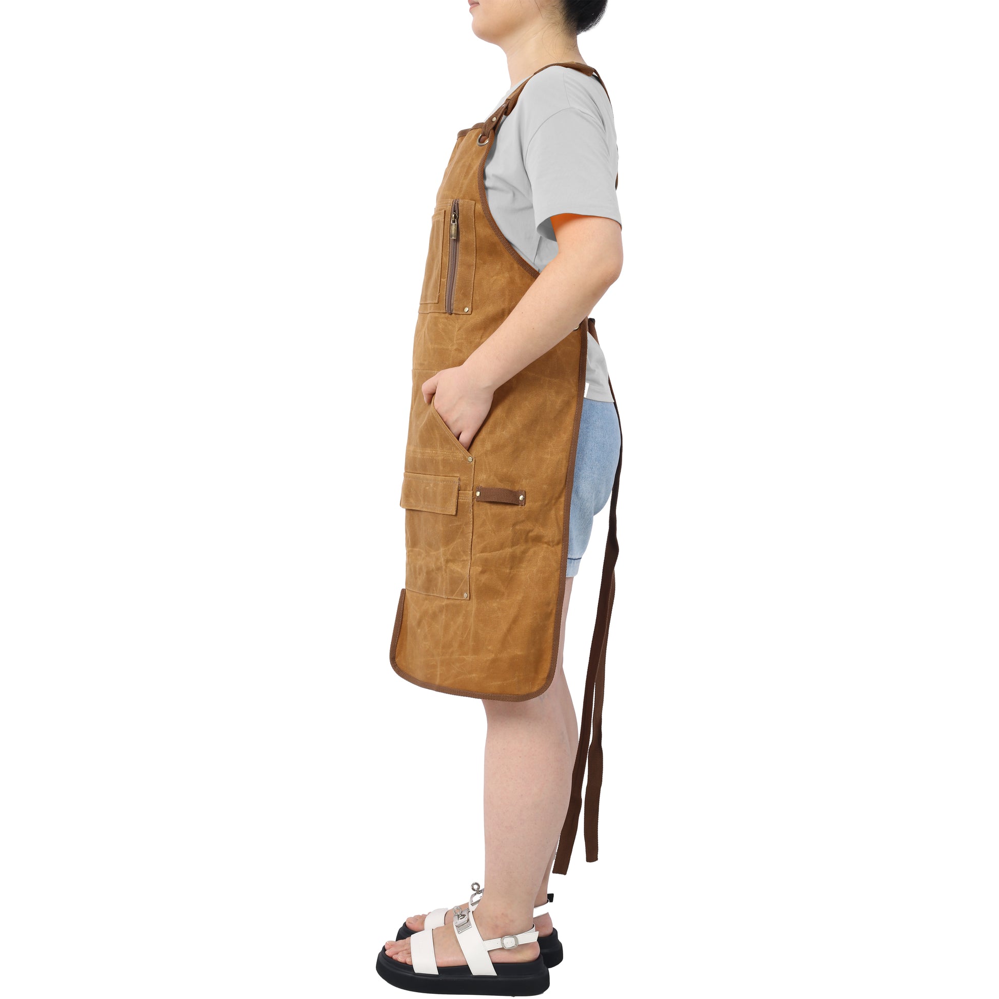 Brown canvas work apron with multiple pockets and zippers for durability