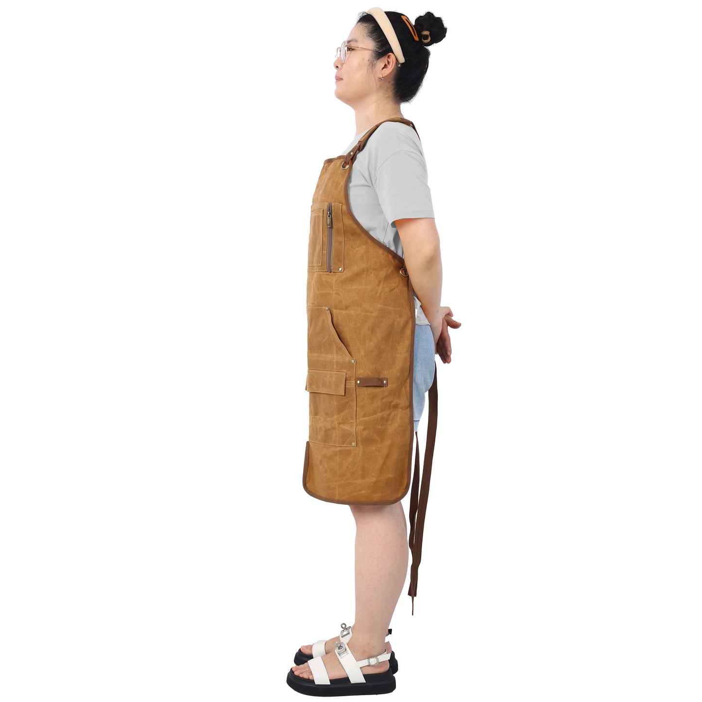 Waxed canvas utility apron in tan with multiple pockets and a zippered chest pocket
