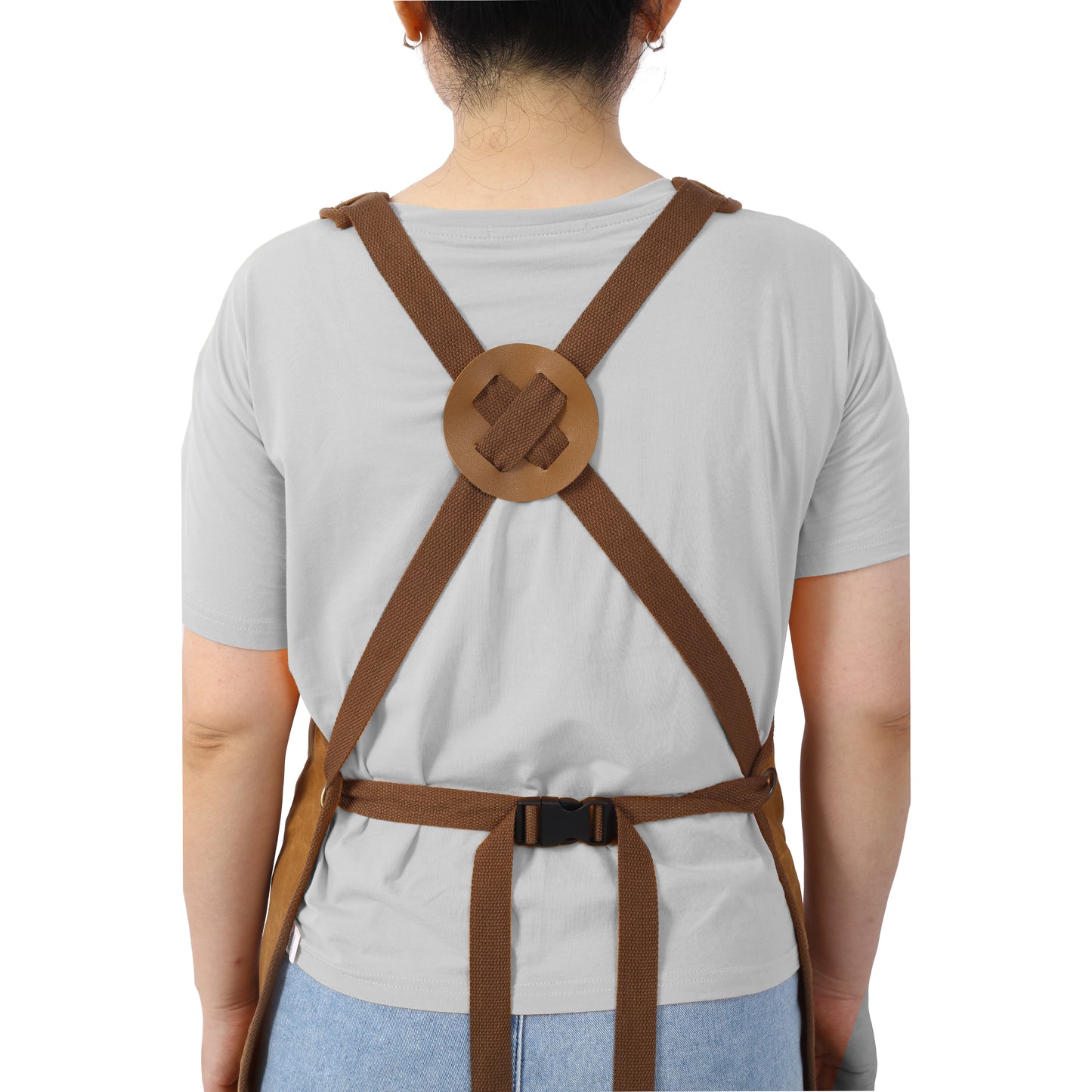 Brown canvas utility apron with adjustable crossback straps and leather detailing for comfort and durability