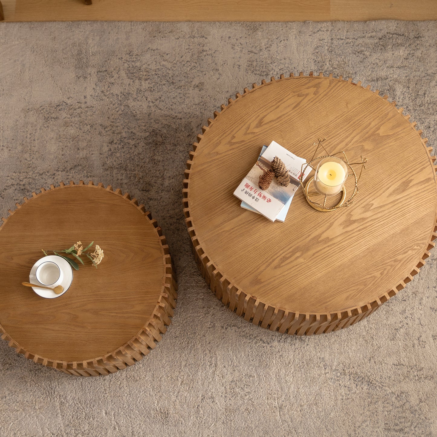 Round oak coffee table with carved wooden legs featuring a candle and books