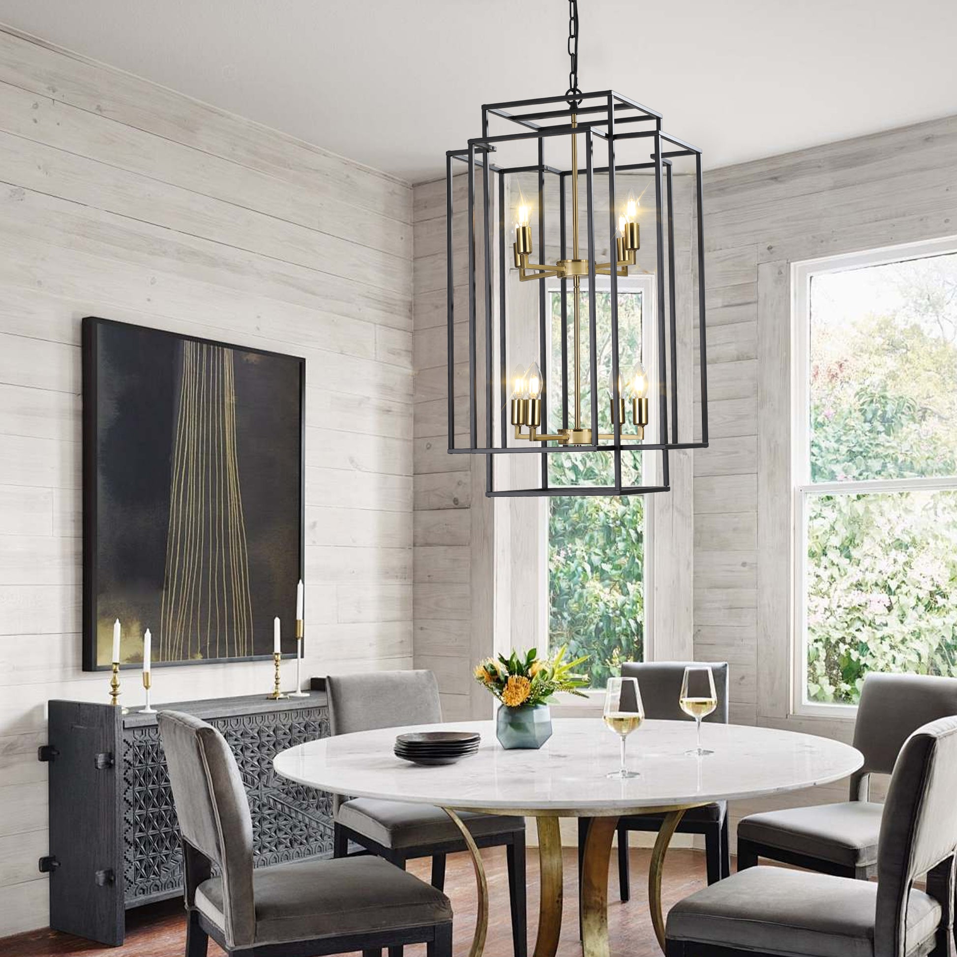 Modern black metal lantern chandelier with gold accents illuminating a dining room