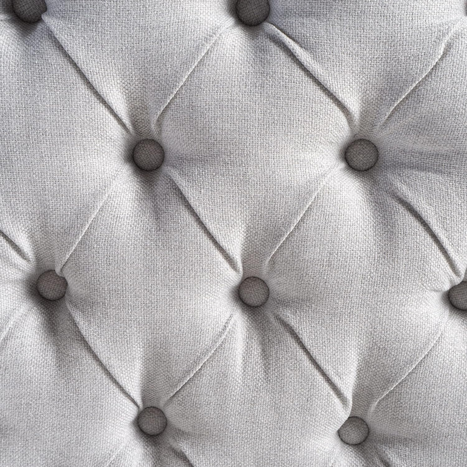 Closeup of light grey fabric tufted upholstery with diamond stitching pattern