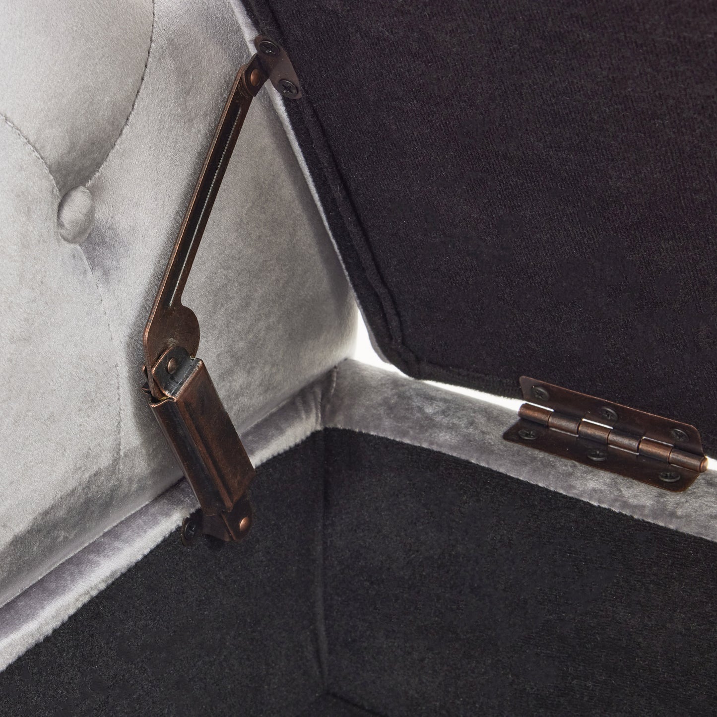 Open grey velvet storage ottoman with antique brass hinge and black fabric interior
