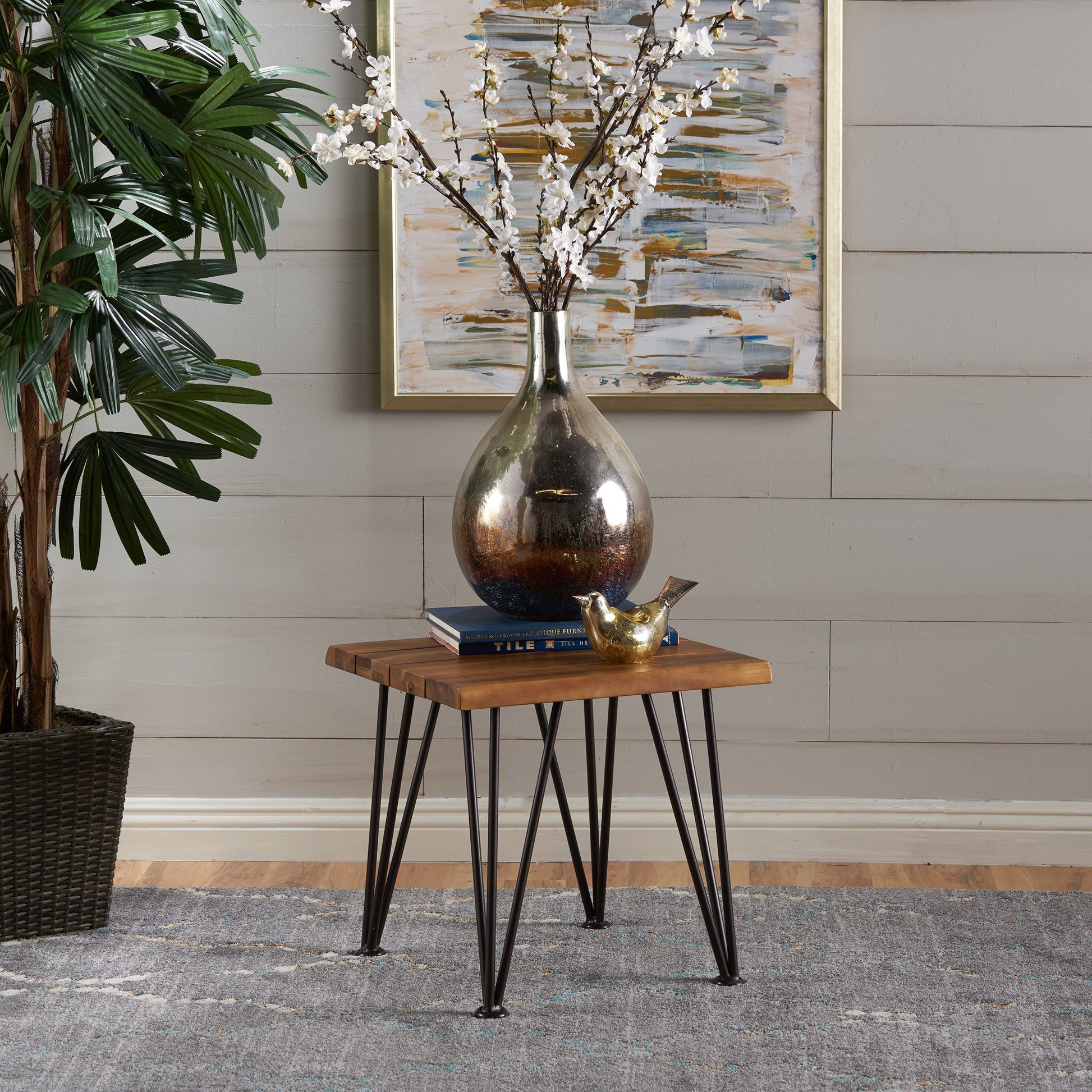Rustic wooden side table with black hairpin legs and metallic vase