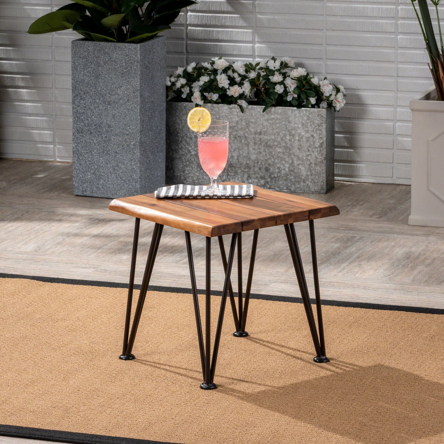 Natural wood square side table with black hairpin legs on outdoor rug