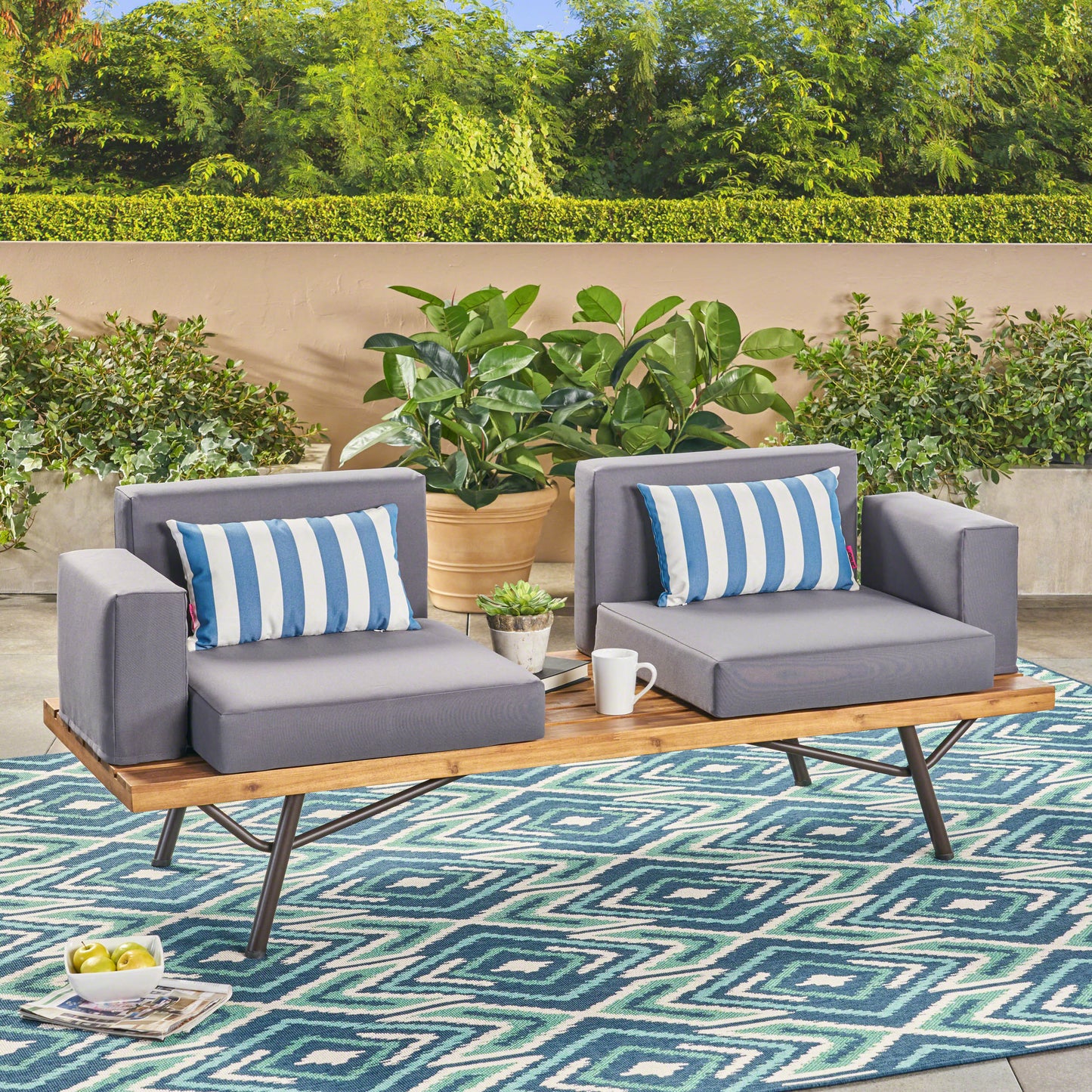 Modern grey outdoor loveseat with blue and white striped cushions on wooden slatted bench