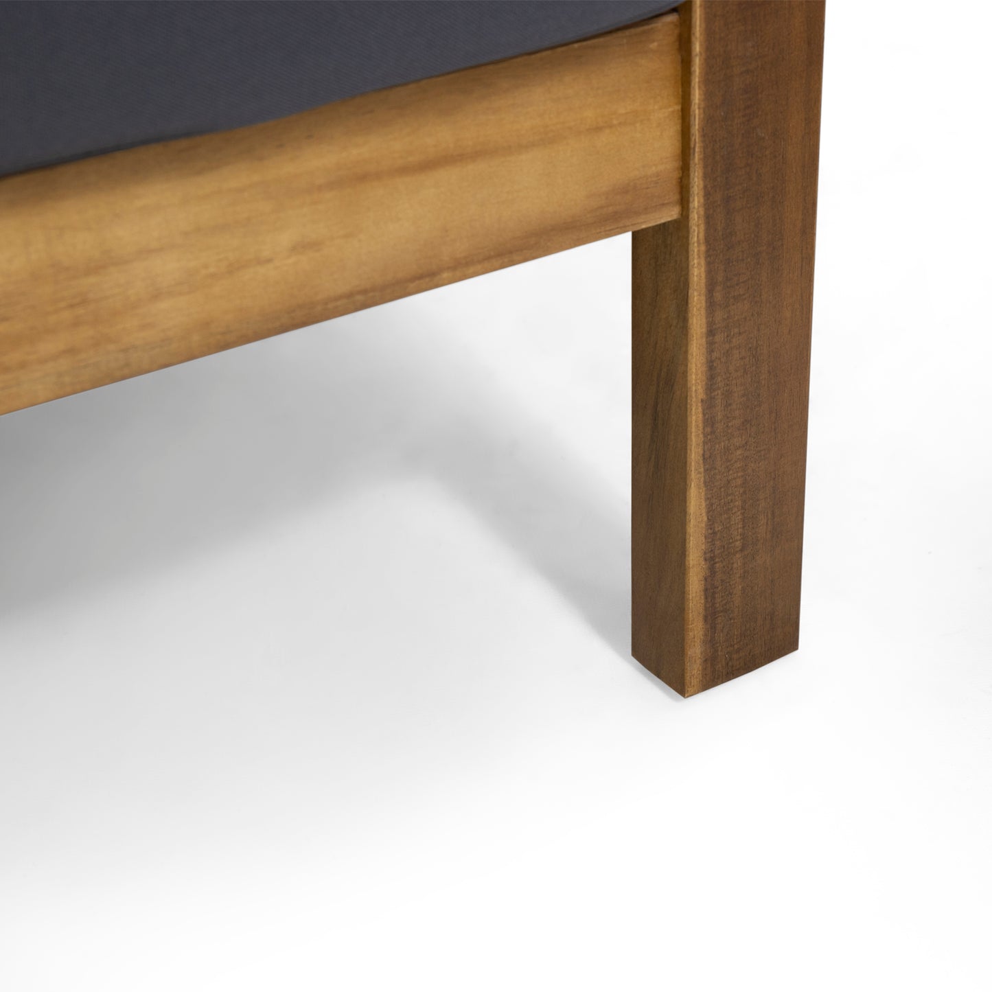 Closeup of a solid dark gray cushion on a wooden outdoor furniture frame