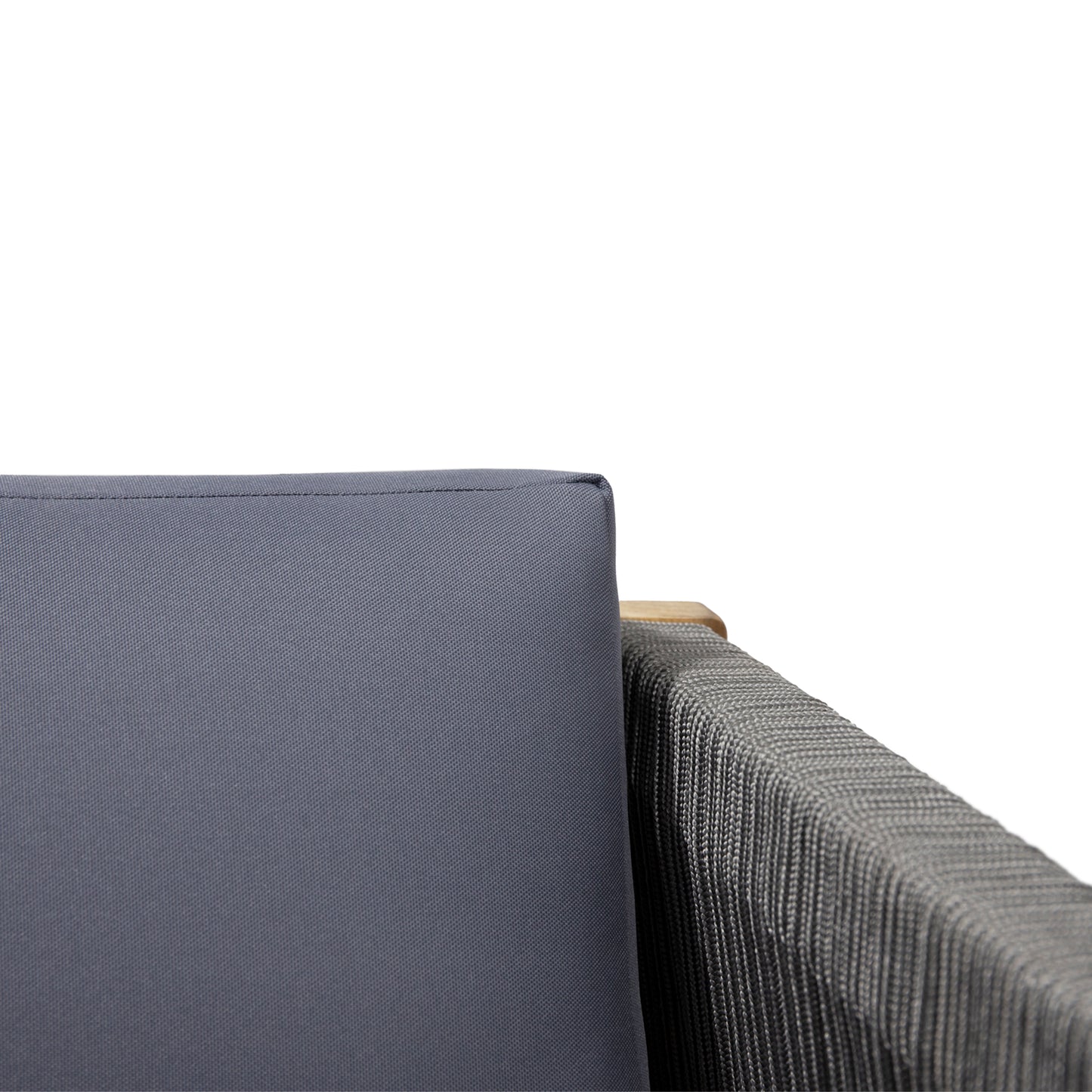 Closeup of a gray outdoor sofa cushion with a woven armrest and wooden trim