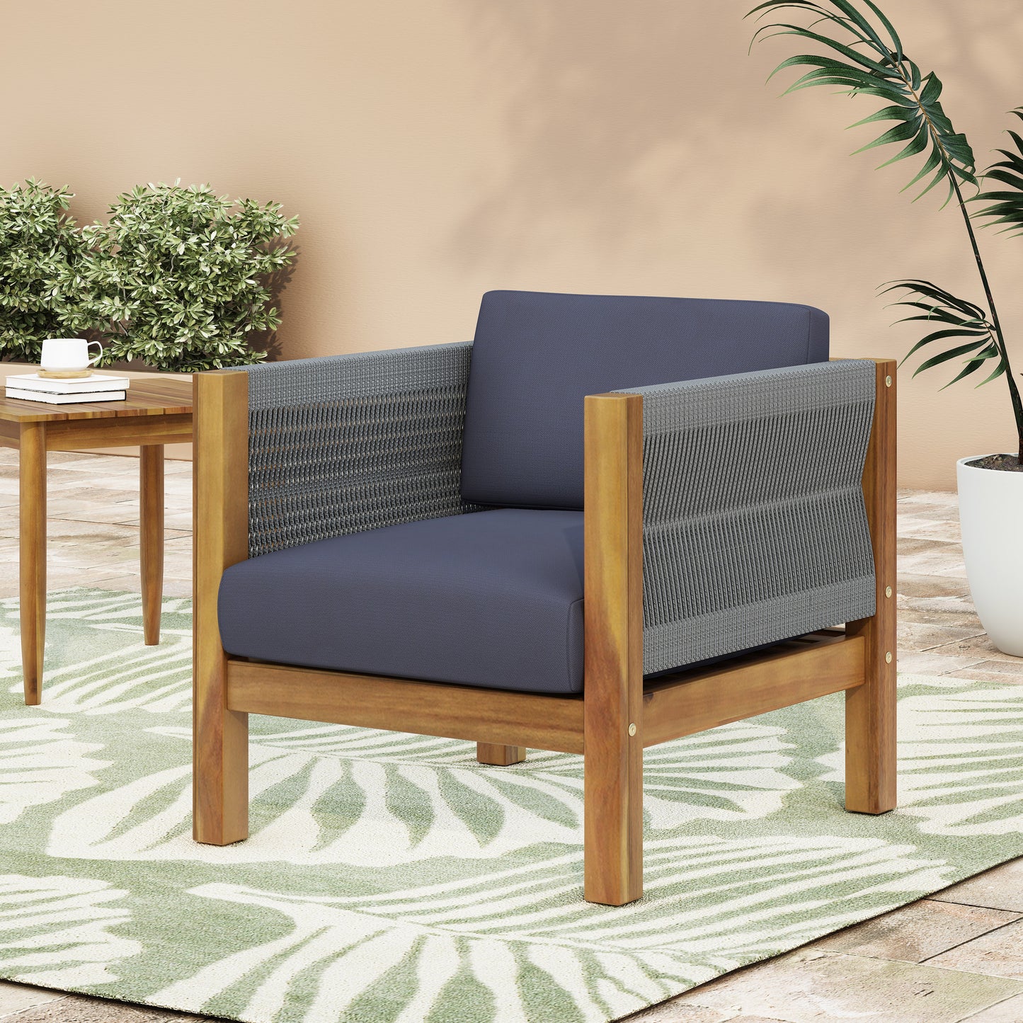 Acacia wood armchair with navy blue cushions and woven grey sides perfect for patio lounging