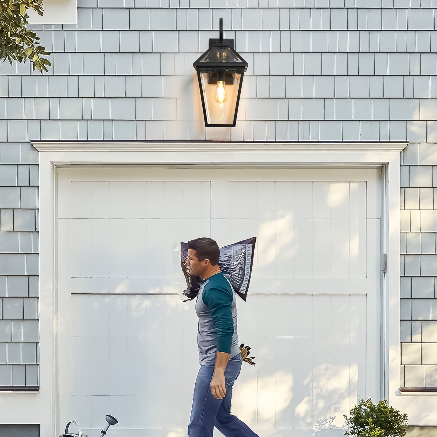 Black metal outdoor wall lantern with clear glass panels and exposed Edison bulb