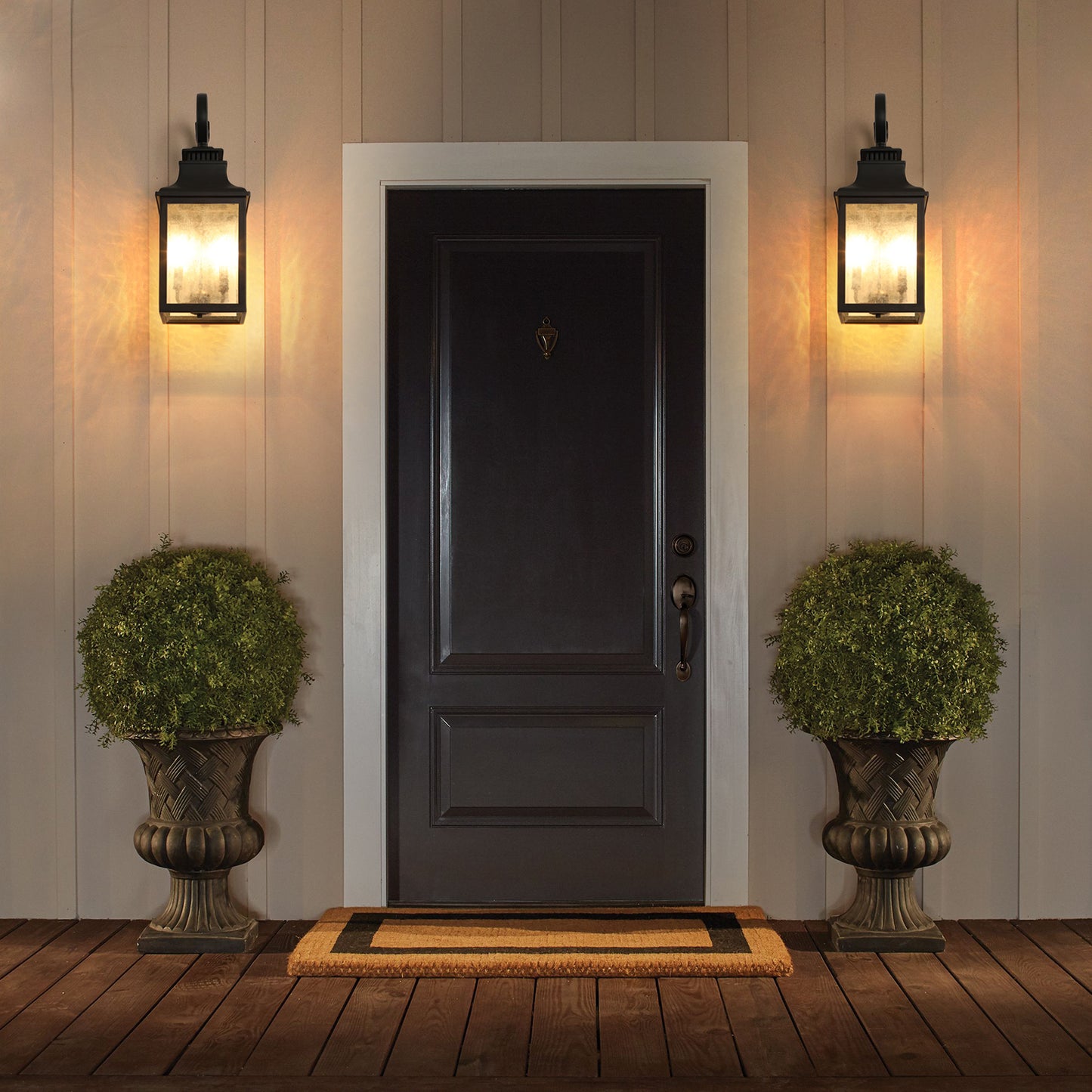 Traditional black outdoor wall lantern with frosted glass panels illuminating a porch