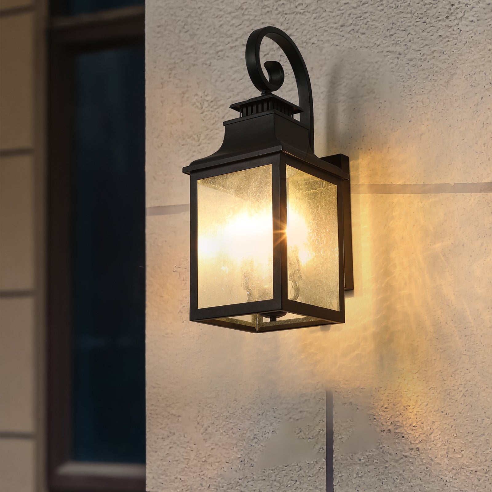 Black traditional outdoor wall lantern with seeded glass panels and decorative scroll arm