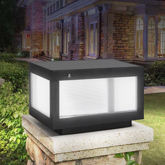 Black modern outdoor post light with clear ribbed glass panels illuminating a garden entrance