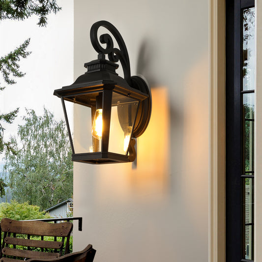 Black traditional lantern outdoor wall light with clear glass panels and ornate scroll arm