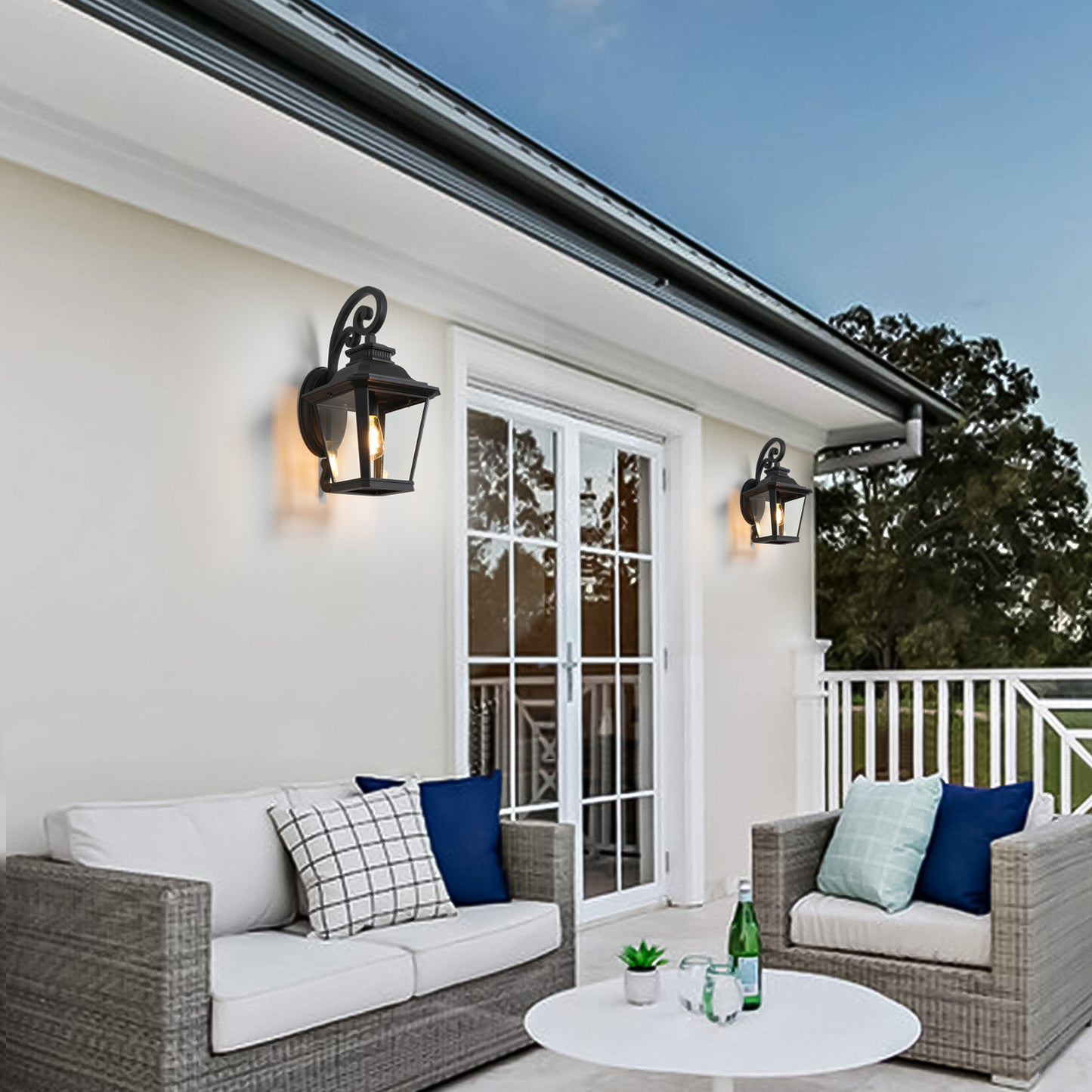 Classic black outdoor lantern sconce with ornate scrollwork and clear glass panels illuminating a patio