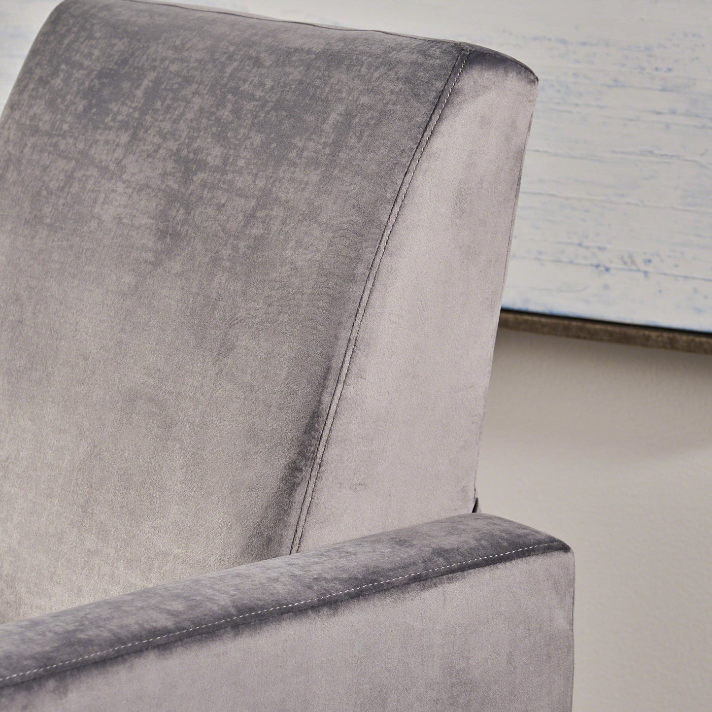 Closeup of a plush grey velvet chair back with visible stitching details