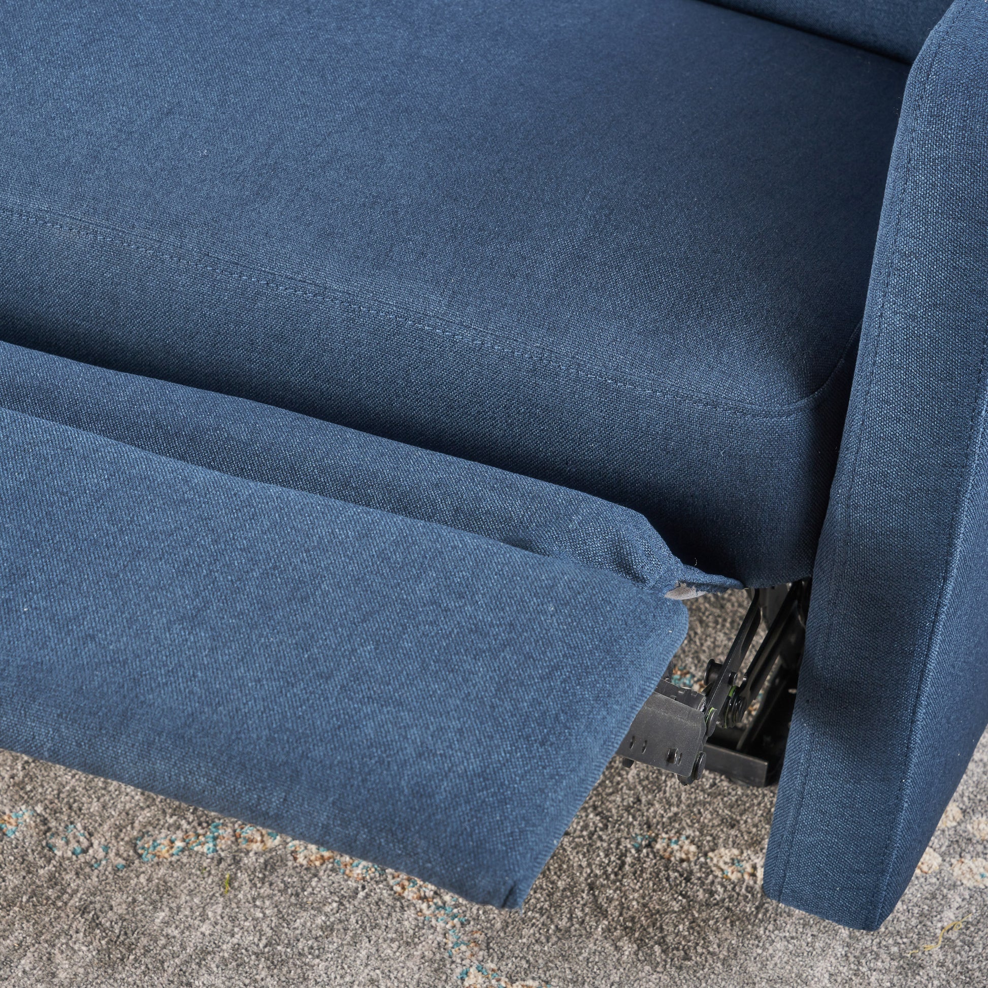 Closeup of a navy blue fabric recliner showing the textured weave and stitching detail