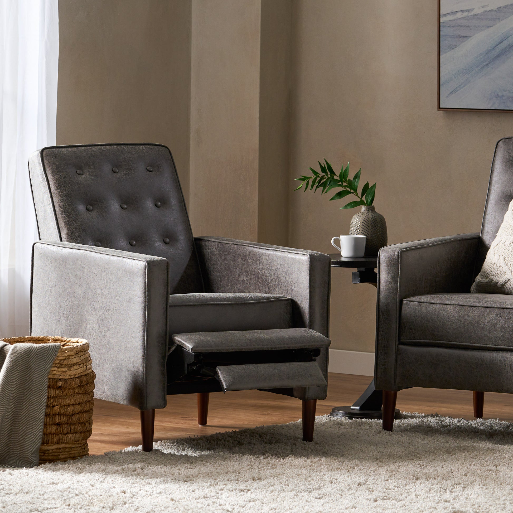 Dark gray tufted recliner chair with exposed wooden legs and footrest extended