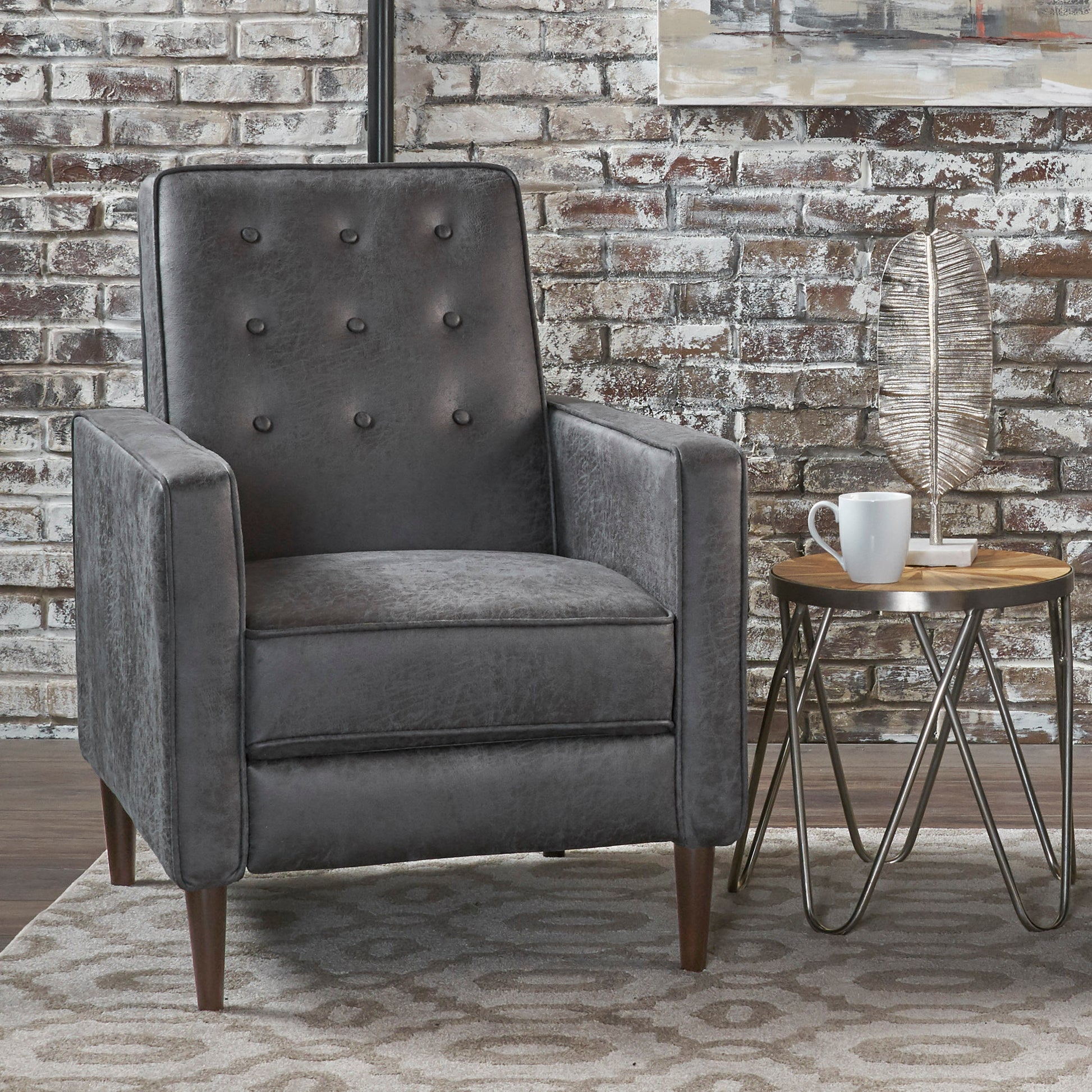 Dark gray tufted accent chair with button details and tapered wooden legs