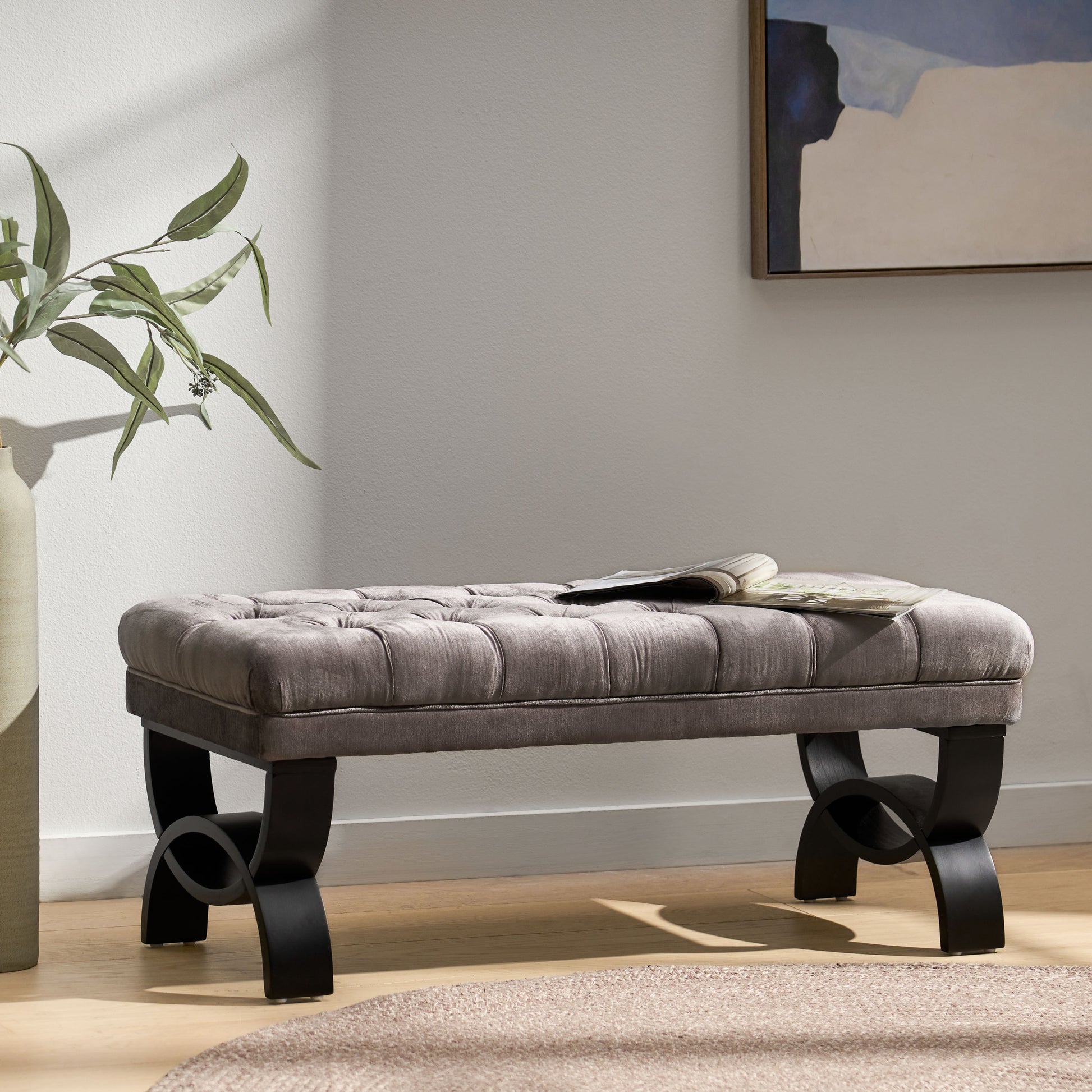 Tufted grey velvet bench with black sculptural legs perfect for entryway seating