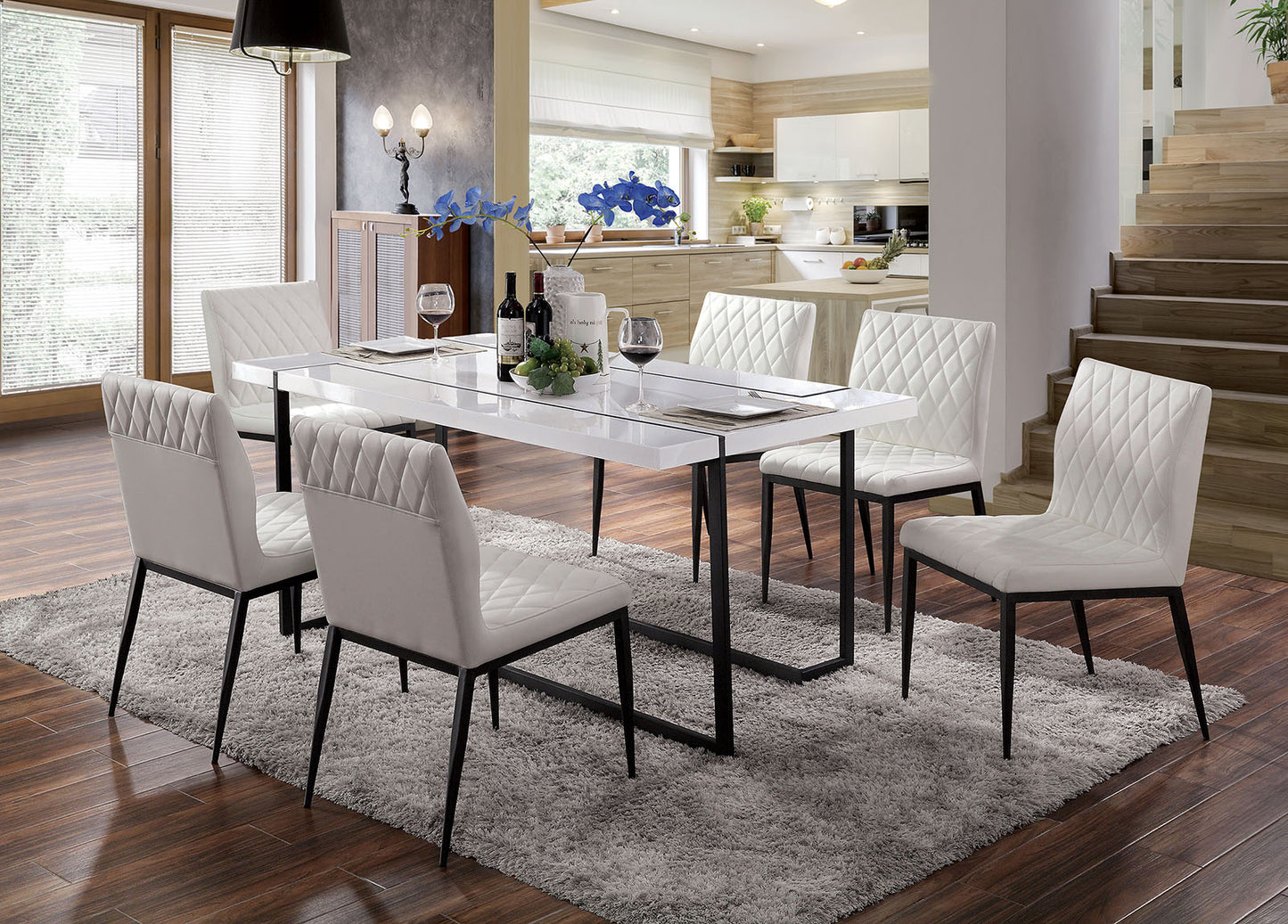 White quilted dining chairs with black metal legs around a glossy white table