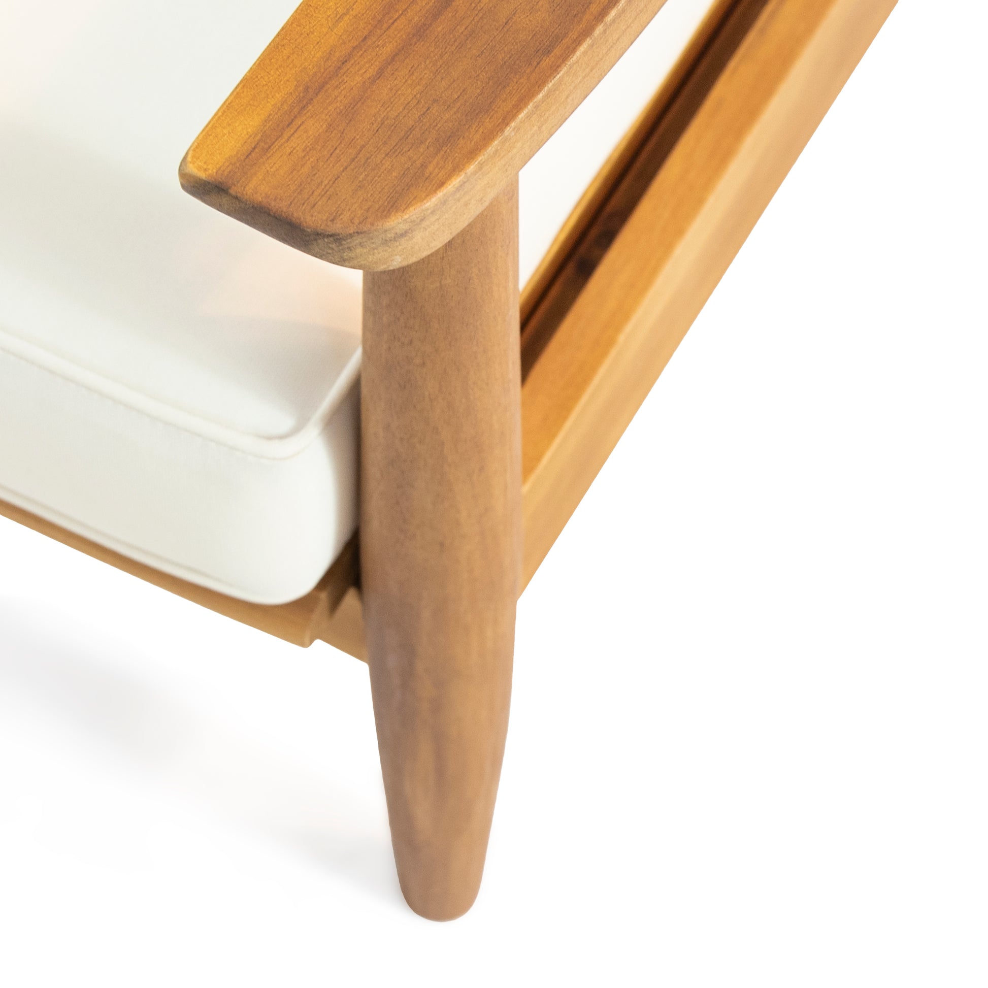 Closeup of a modern wooden armchair leg and armrest with a white cushion