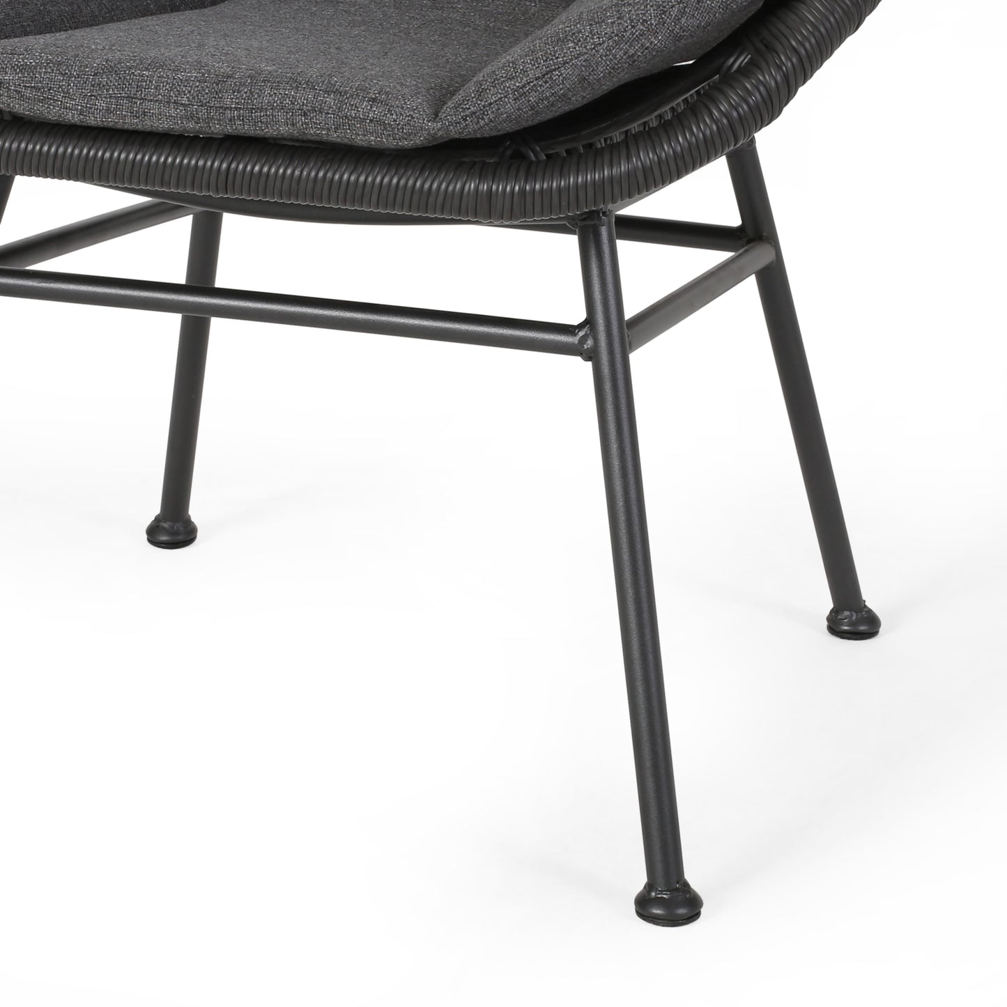 Closeup of gray upholstered chair seat and woven rattan base with black metal legs
