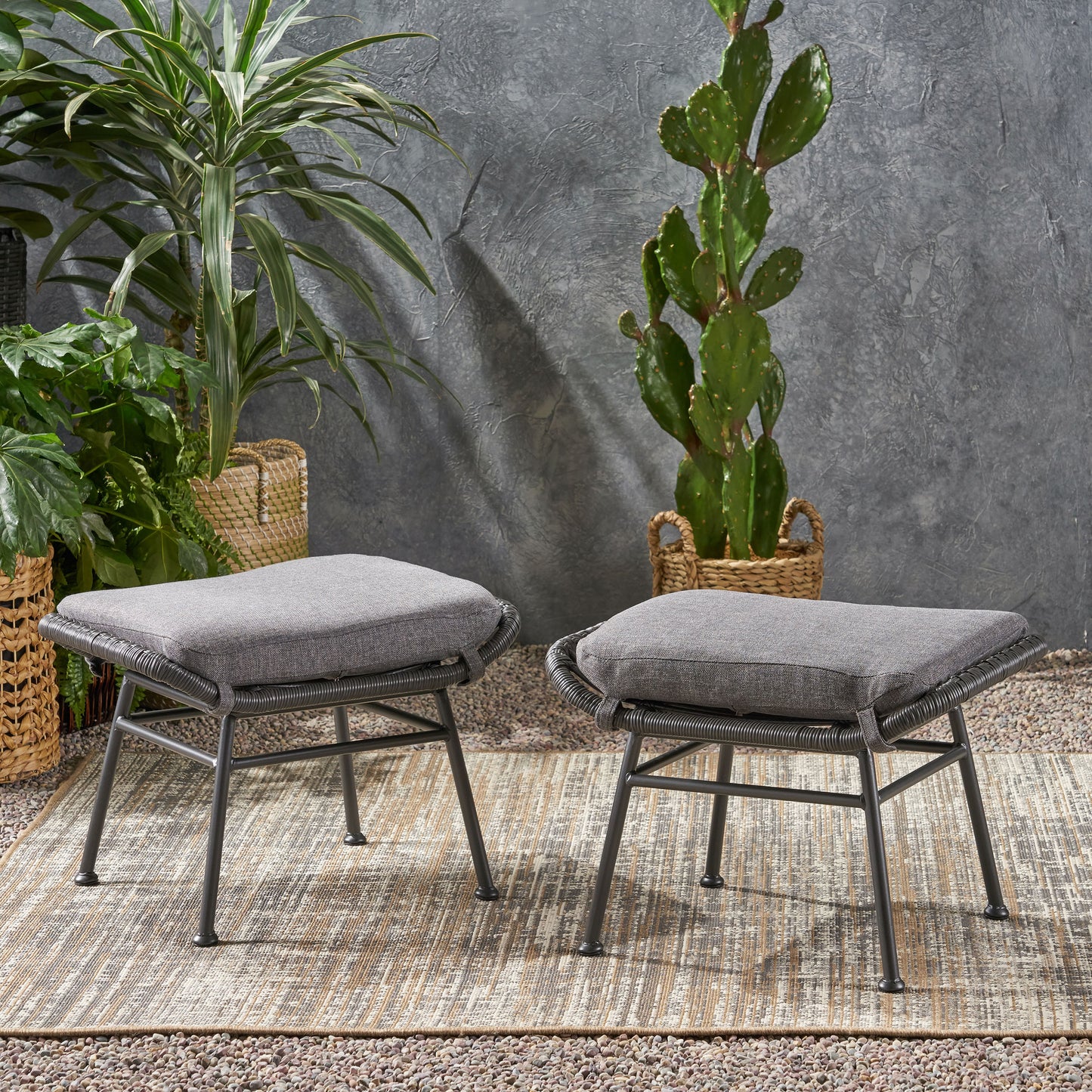Two grey upholstered ottomans with woven rope detailing on a patio rug