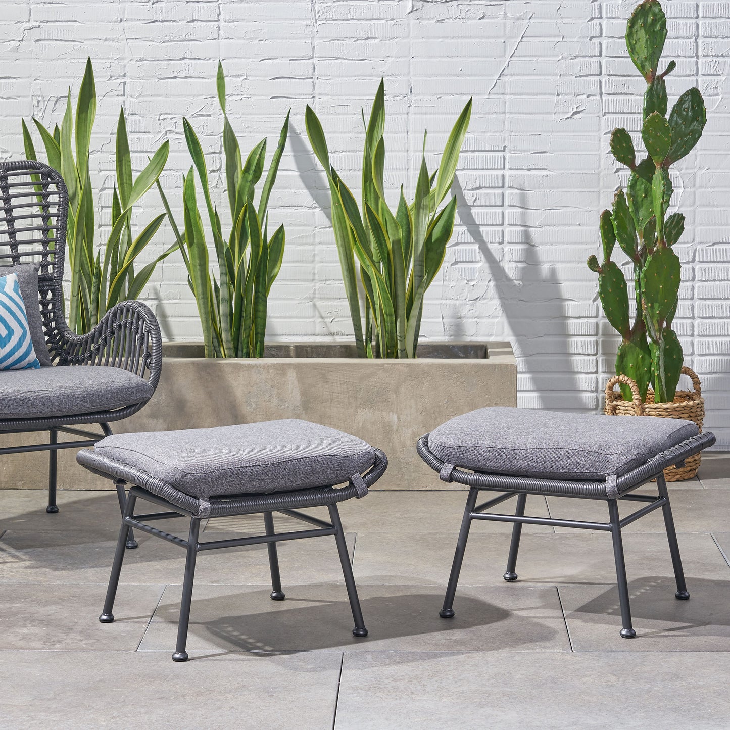 Gray woven patio ottoman with a padded seat perfect for outdoor relaxation