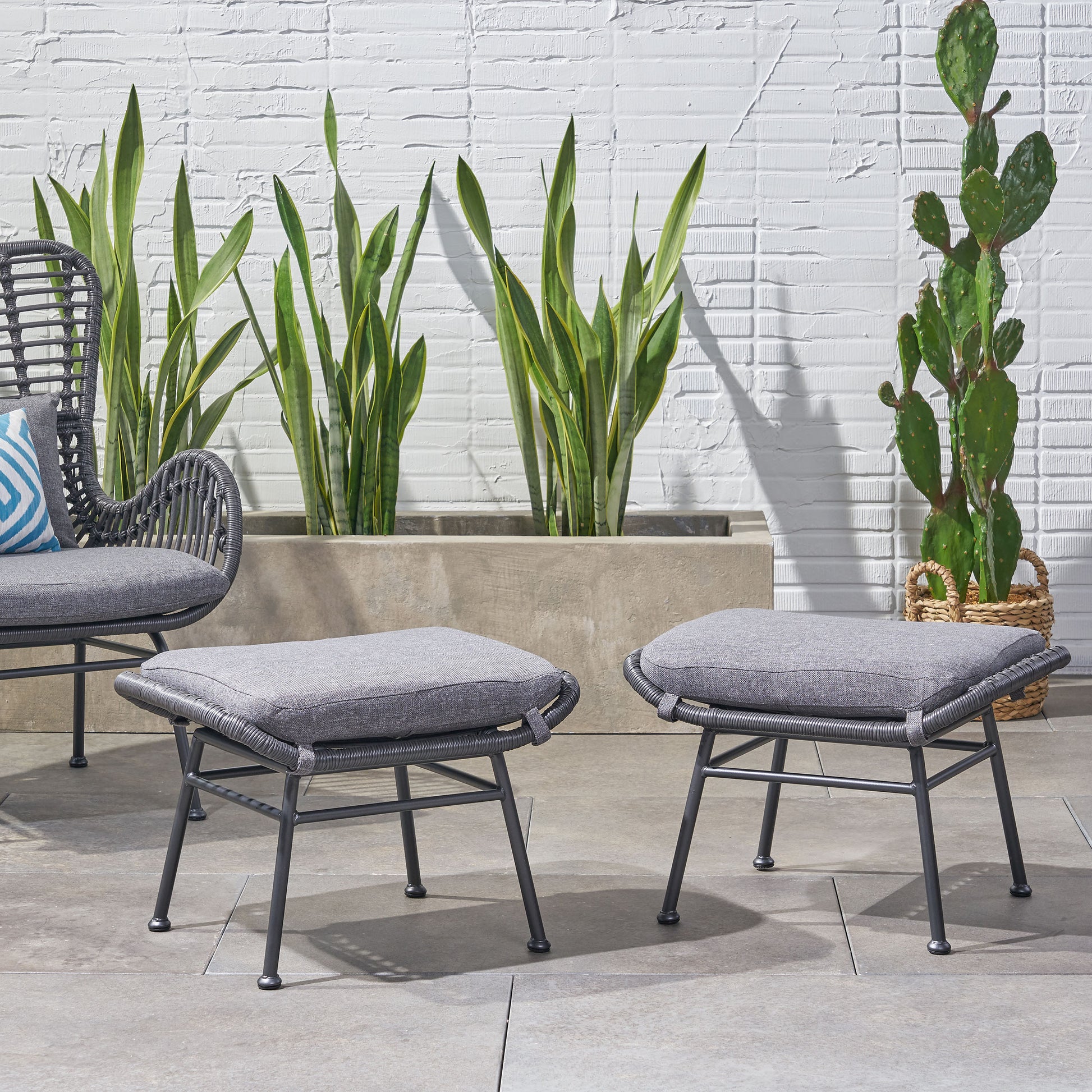 Gray woven patio ottoman with a padded seat perfect for outdoor relaxation