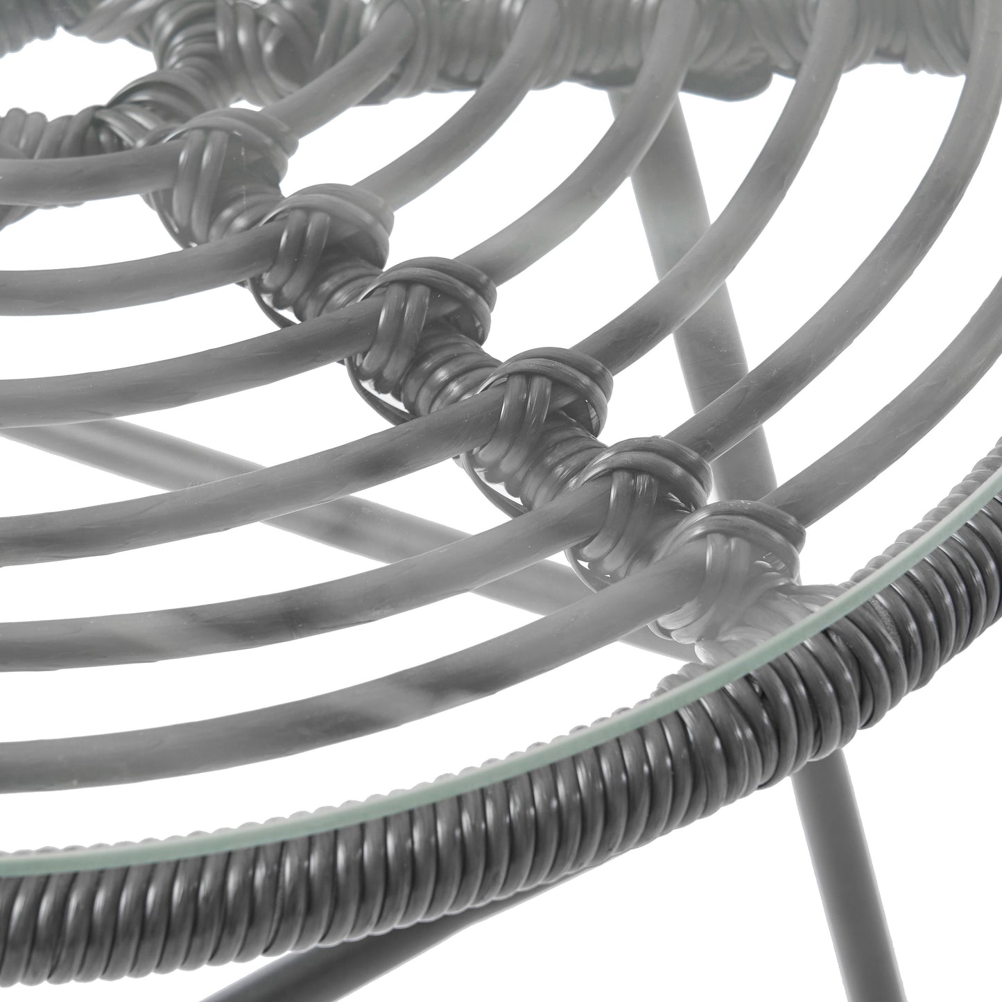 Closeup of woven grey rattan chair frame with glass top detail
