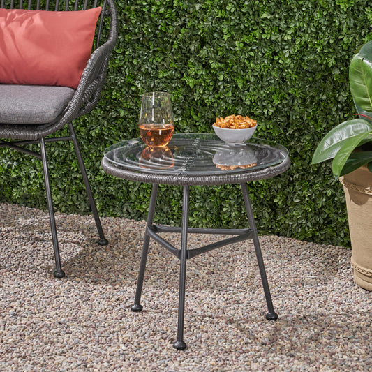 Round glass top side table with dark metal frame perfect for patio seating