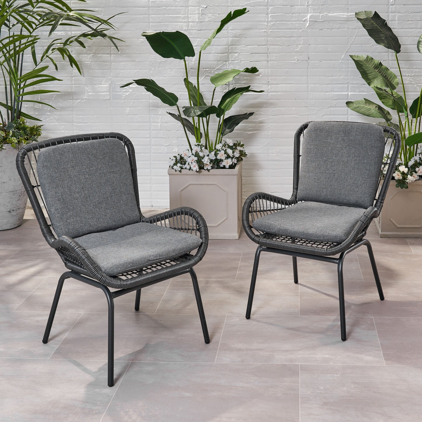 Two grey woven patio chairs with comfortable cushions perfect for outdoor relaxation