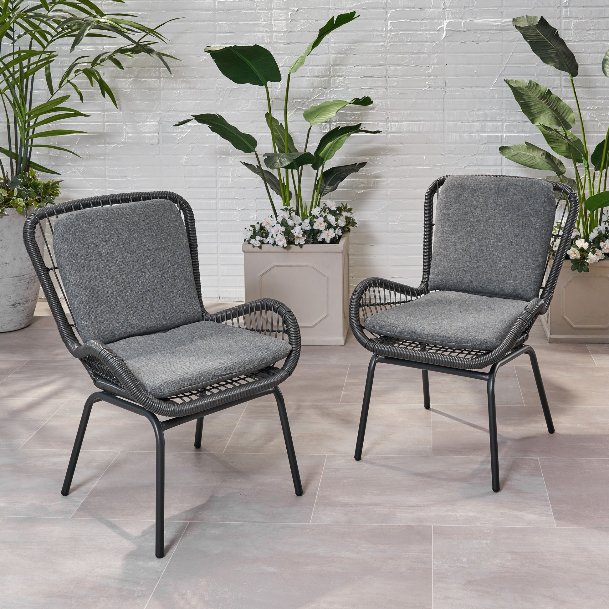 Two grey woven patio chairs with comfortable cushions perfect for outdoor relaxation