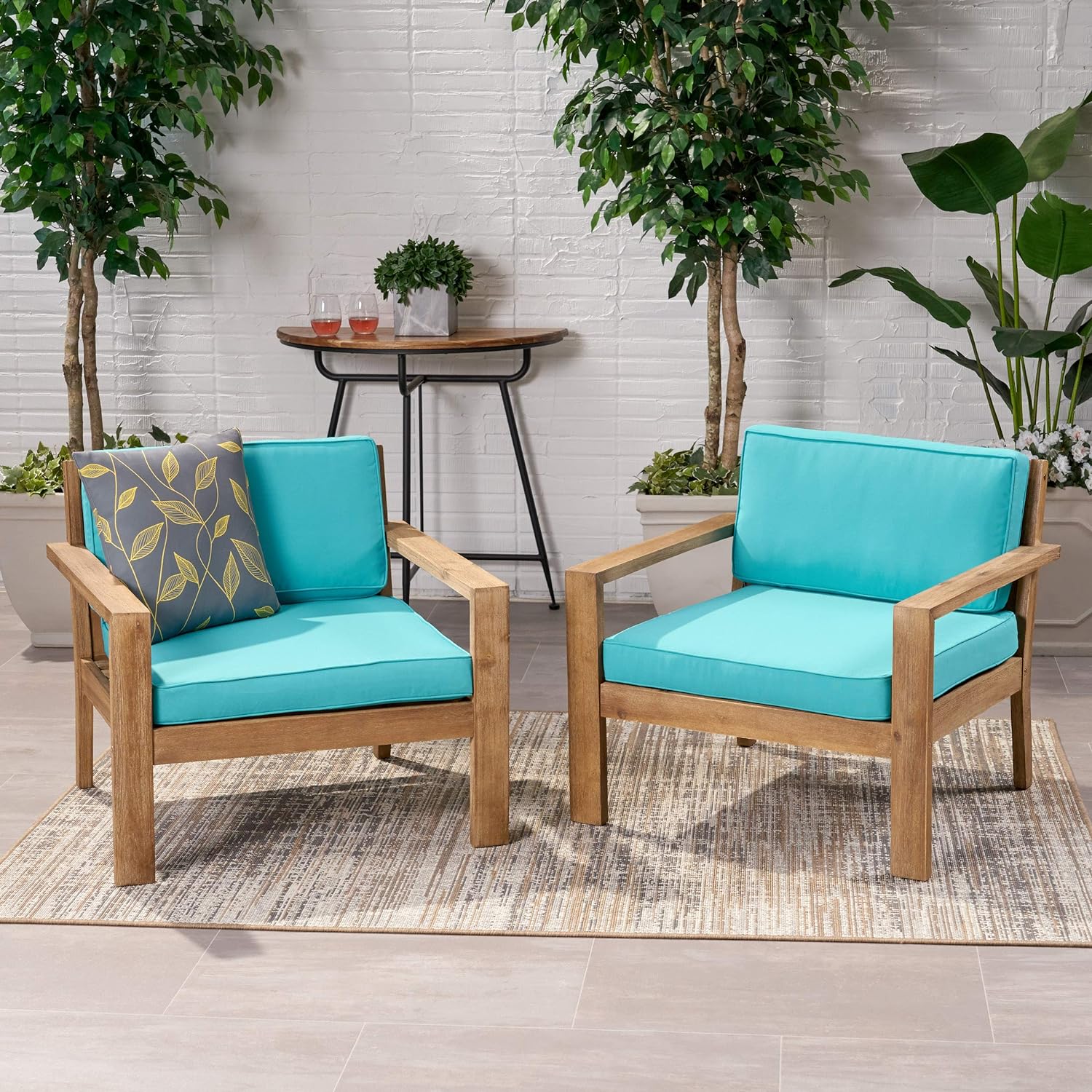 Two wooden outdoor chairs with bright turquoise cushions offer a comfortable seating option
