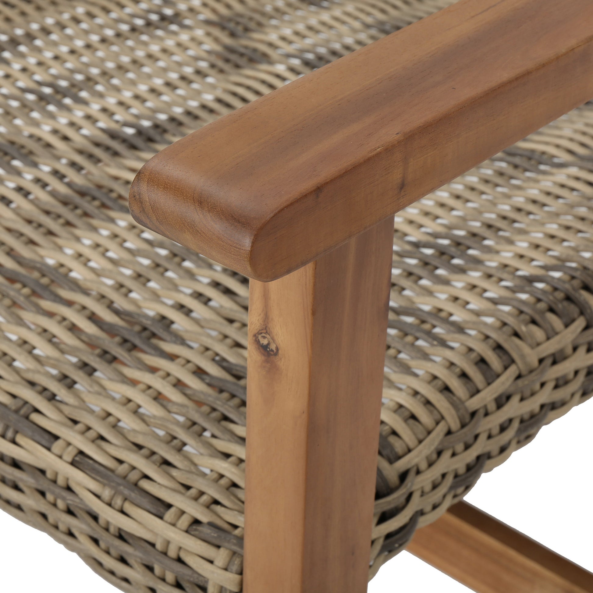 Closeup of a naturaltoned rattan armchair with a solid wood armrest and legs